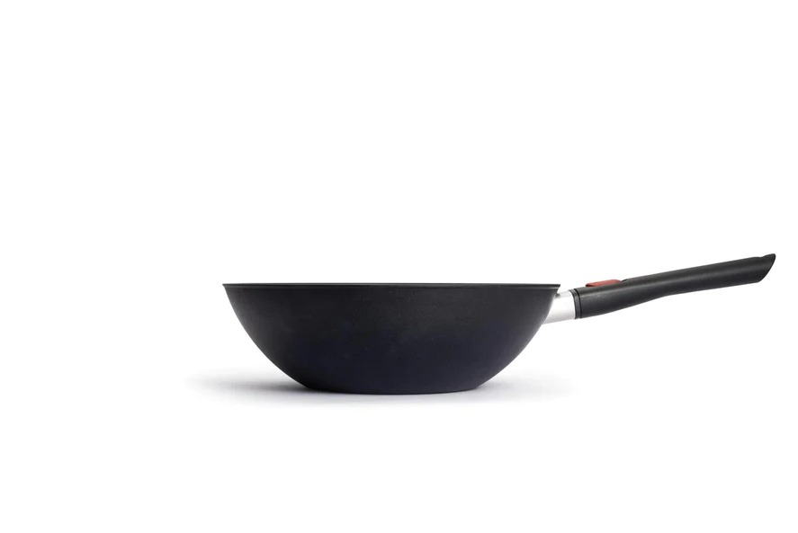 Von rechts aufgenommene Ansicht eines schwarzen Woks mit langem Griff Der Wok liegt auf weißem Hintergrund