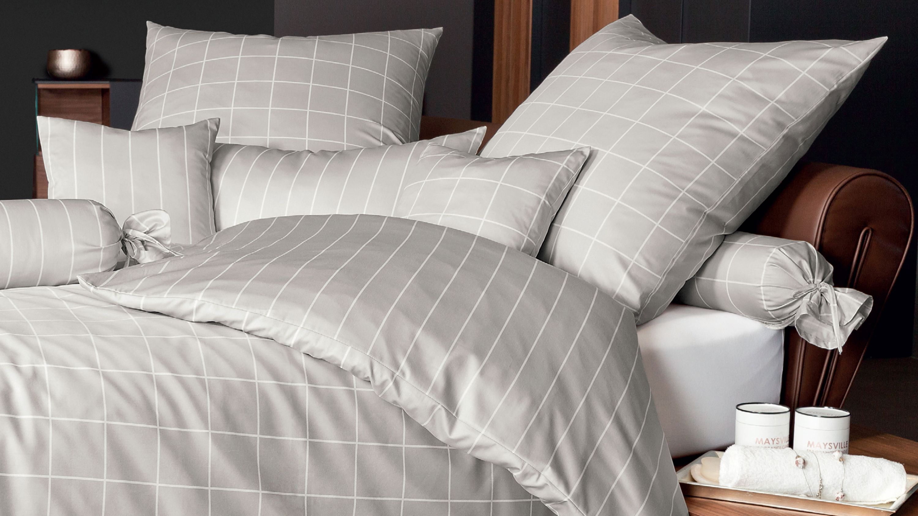 Bettwäsche-Set mit Kissen und Decke in hellgrau mit weißem Karomuster auf einem Bett