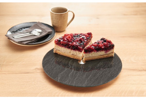 Runde Servierplatte in schwarzer Schieferoptik mit Beerentorte auf Holzoberfläche  daneben Teller und Tasse