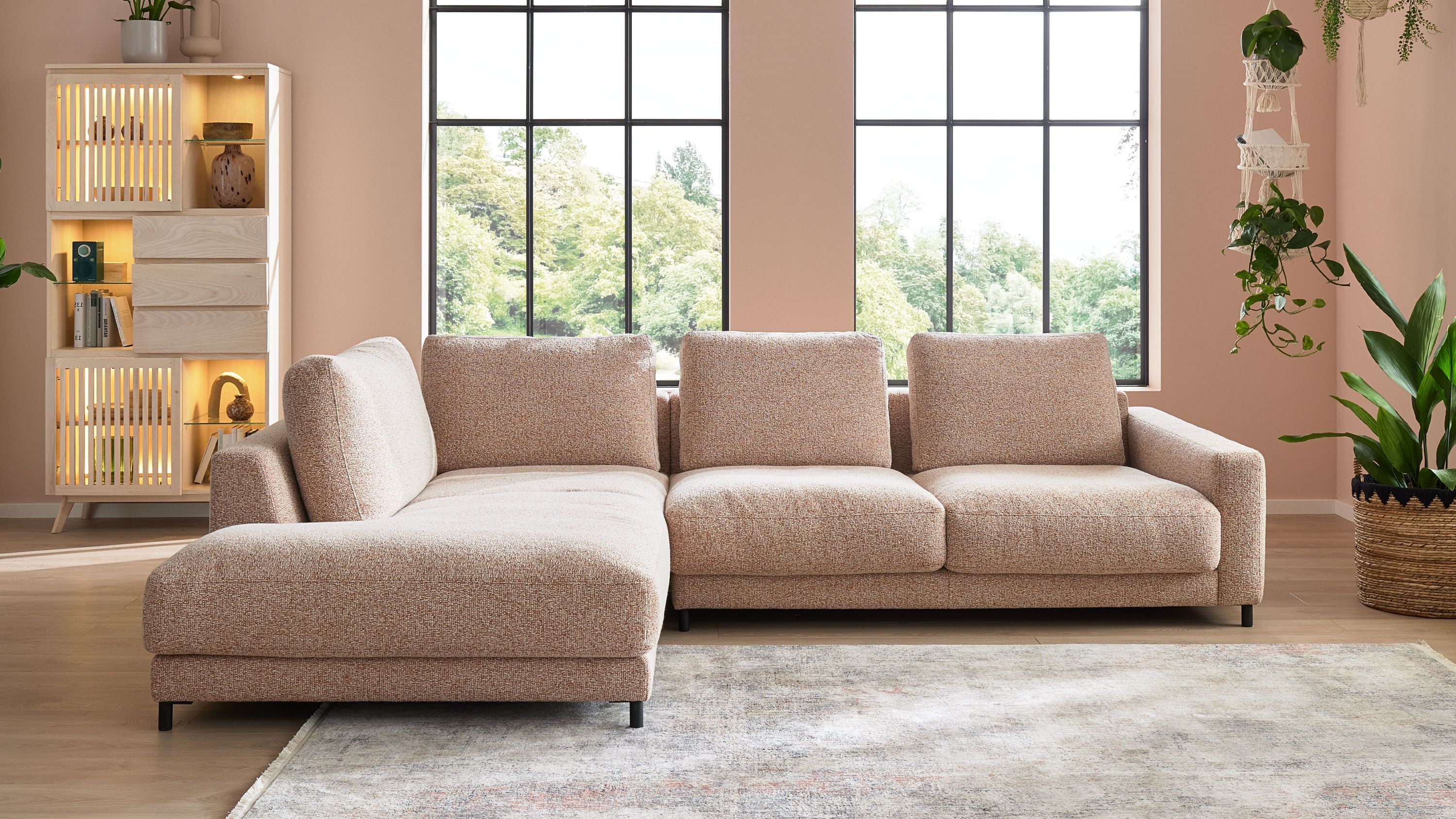 Ecksofa mit meliertem rostfarbenem Bezug und Metallfüßen in einem hellen Wohnzimmer