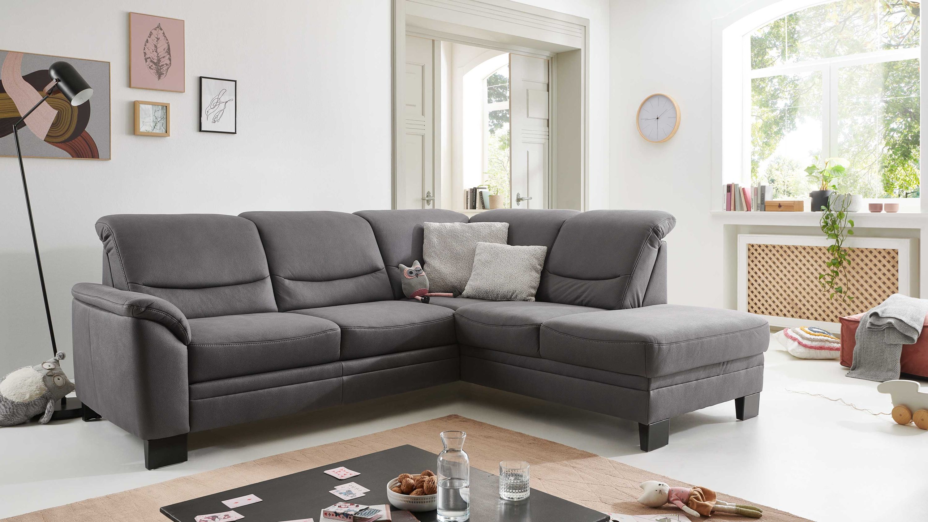 Ecksofa mit grauem Stoffbezug und schwarzen Metallfüßen in modernem Wohnzimmer