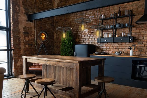 Industrial Kitchen Design Küche im Industrial-Stil mit Backsteinwand, Holzinsel und Metallhockern, aus frontaler Perspektive aufgenommen.