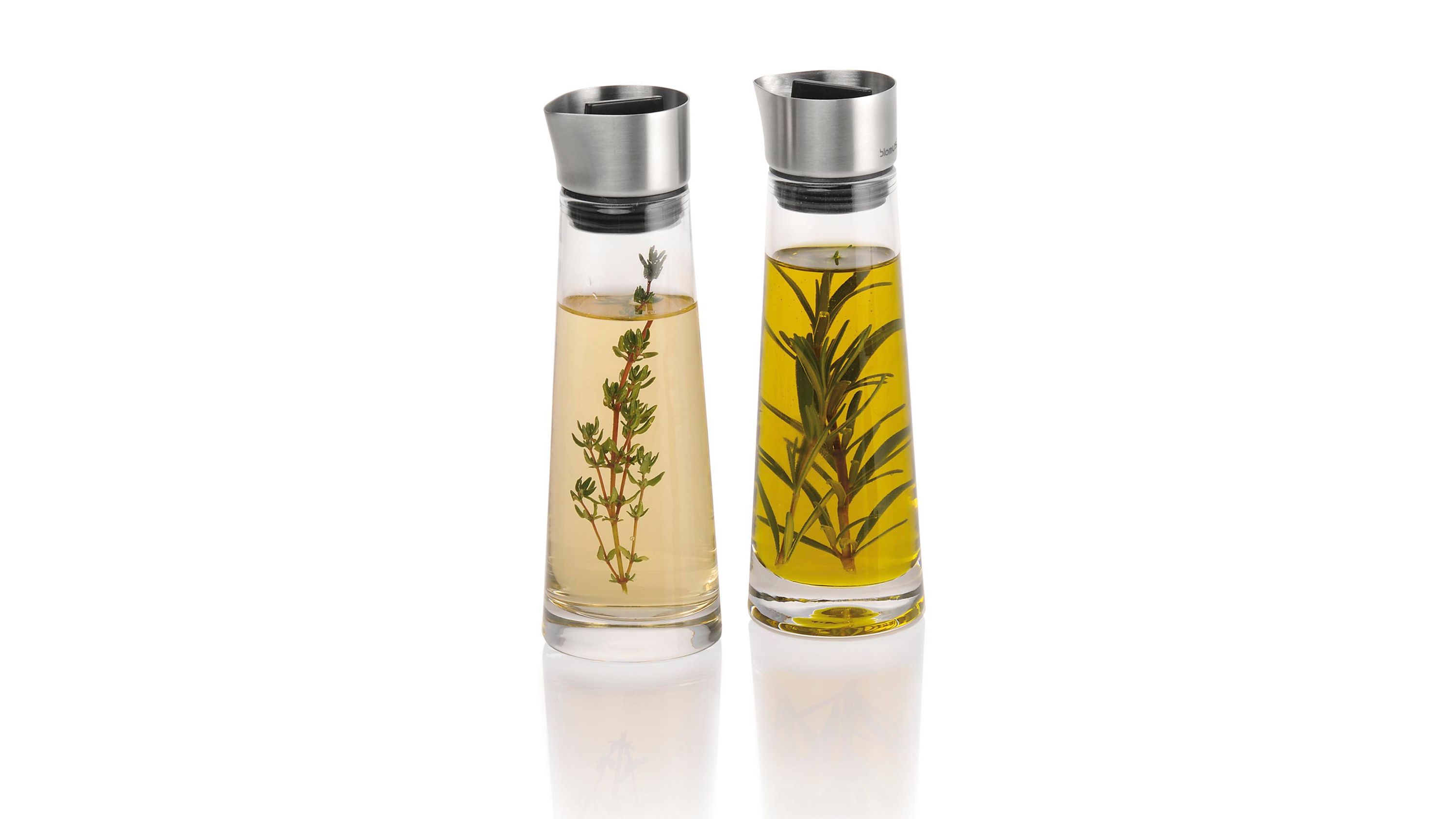 Essig und Öl Set aus Glas mit Edelstahlkappen Zwei schlanke Karaffen aus klarem Glas mit matten Edelstahlkappen gefüllt mit Öl und Essig und Kräutern
