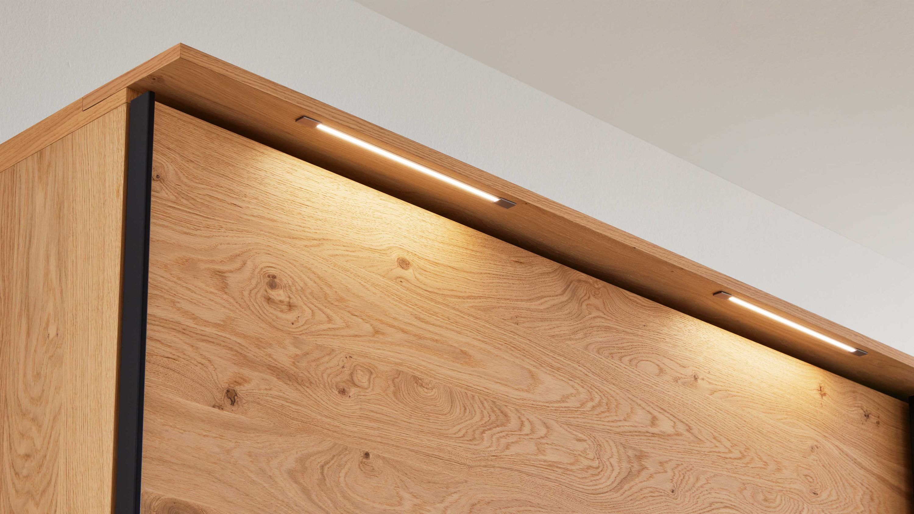 Zweiteiliges Schlafzimmermöbel mit Stabbeleuchtung Zweiteiliges Schlafzimmermöbel mit Holzoptik und integrierter Stabbeleuchtung oben