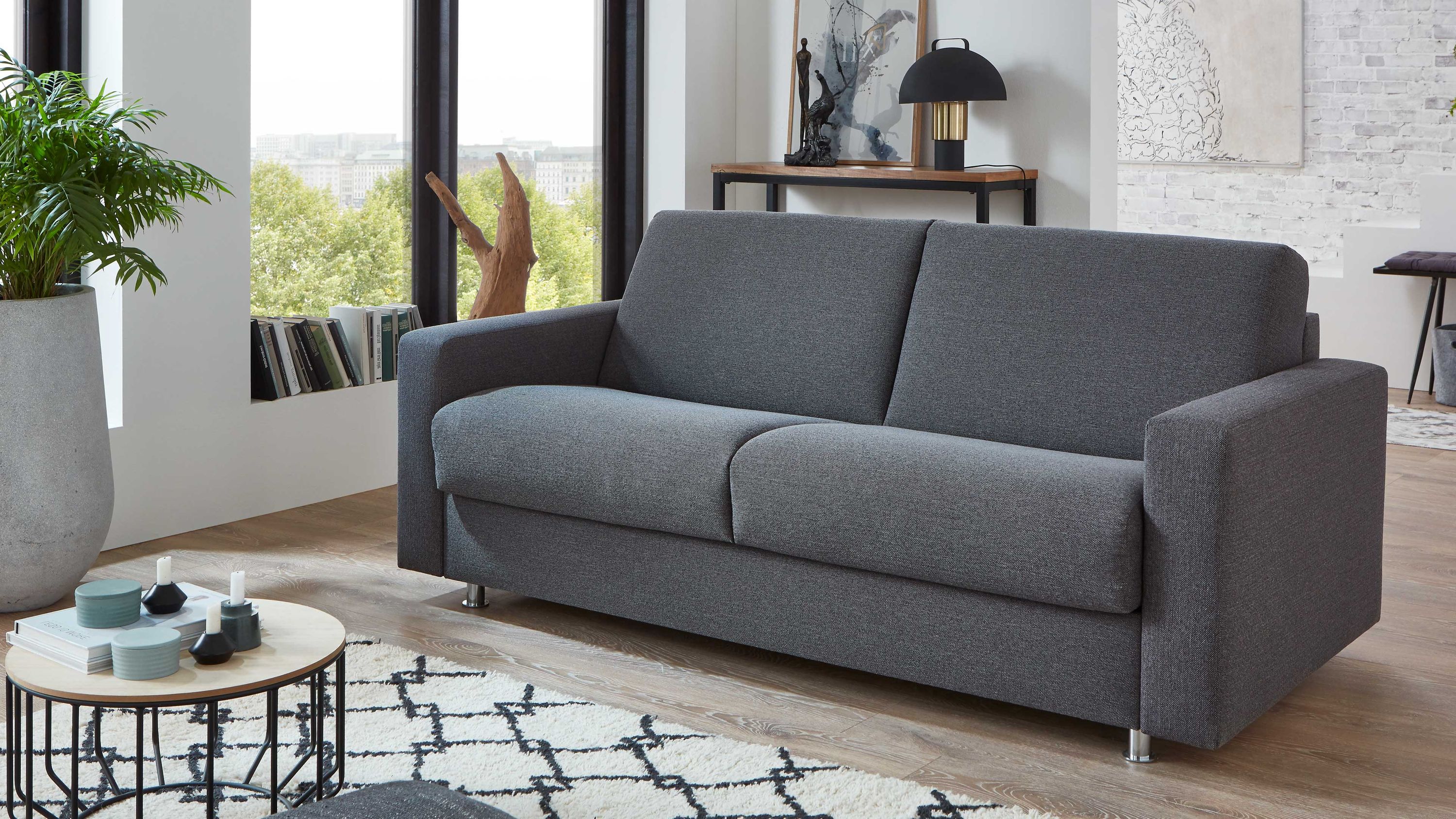 Anthrazitfarbenes Sofa mit Chromfüßen Anthrazitfarbenes Sofa mit geraden Armlehnen und Chromfüßen in modernem Wohnzimmer
