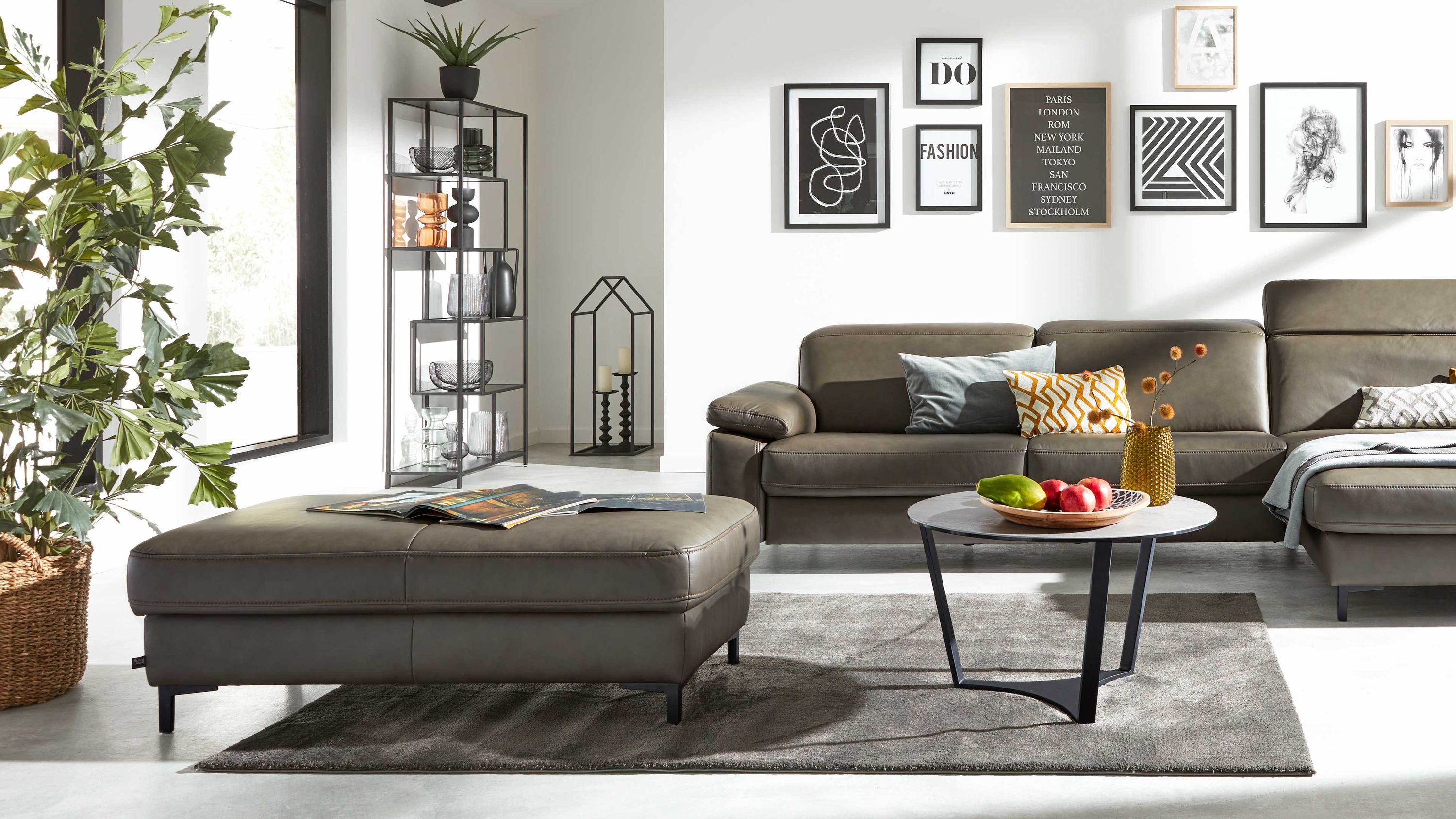 Rechteckiger Hocker in steingrau mit schwarzen Metallfüßen in einem modernen Wohnzimmer