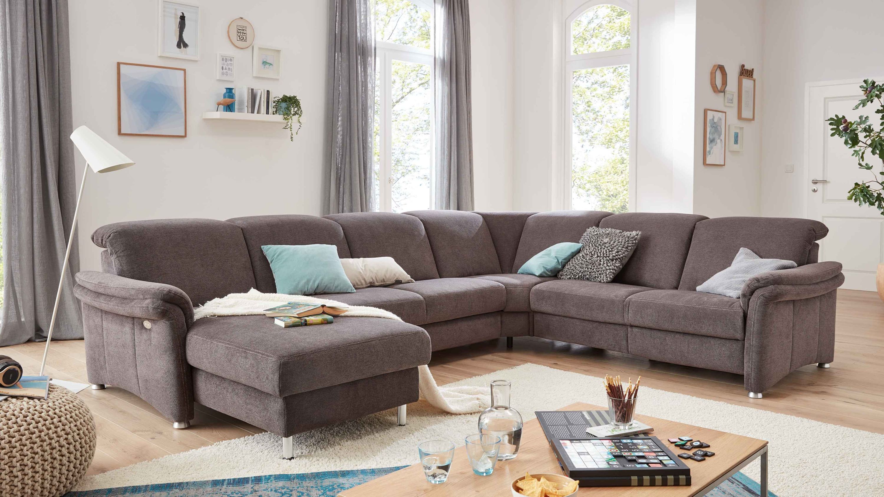 Große graue Wohnlandschaft mit Chennille-Bezug und Aluminiumfüßen in hellem Wohnzimmer