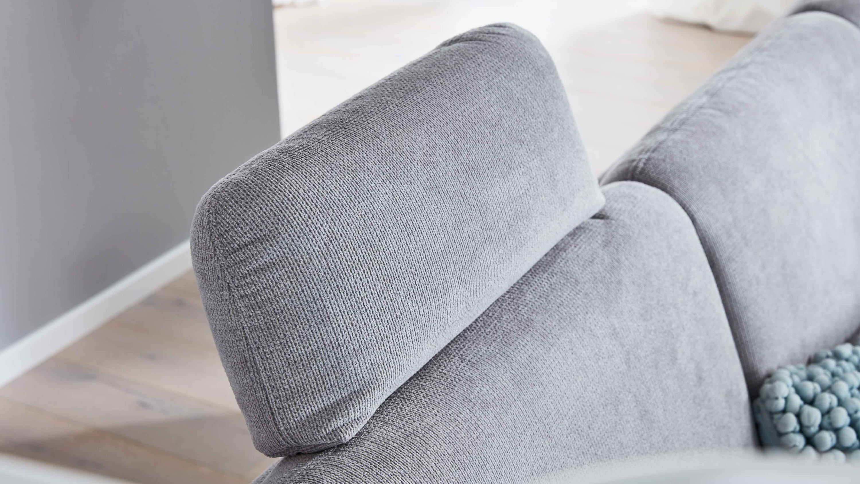 Silberfarbene Kopfstütze aus Chenille auf grauem Sofa