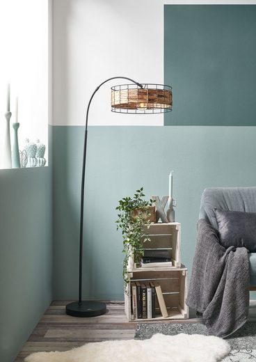 Stehleuchte mit schwarzem Gestell und braunem Zylinderschirm  frontal inszeniert neben Sofa im modernen Wohnambiente