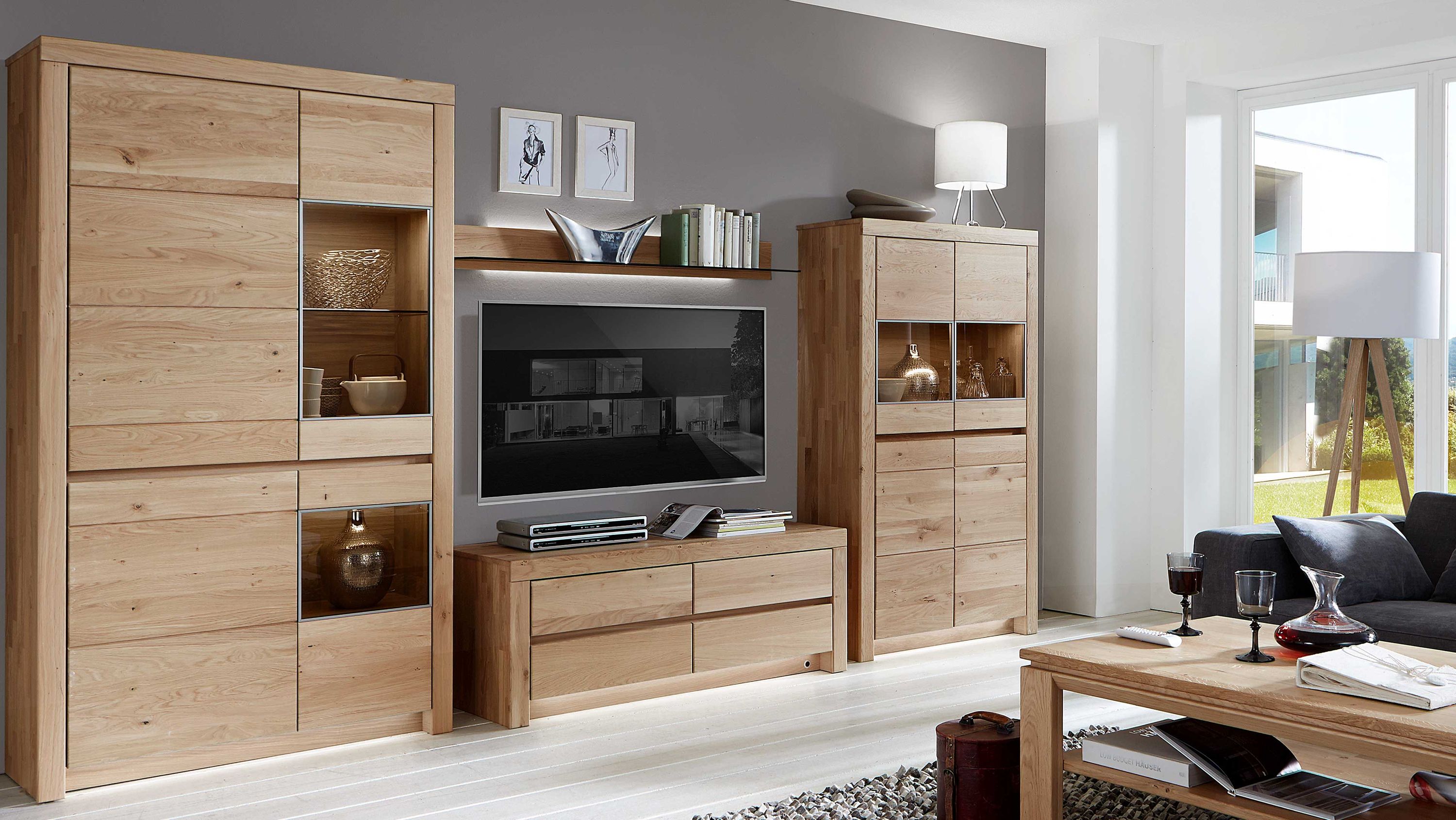 Vierteilige Wohnwand aus hellem Holz mit Schränken und Regalen Vierteilige Wohnwand aus hellem Holz mit Schränken Regalen und Glasvitrinen in modernem Wohnzimmer