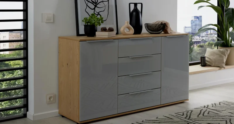 Kommode Modernes Sideboard mit grauen Hochglanzfronten, Holzrahmen und dekorativer Ablage mit Vasen und Bildern.