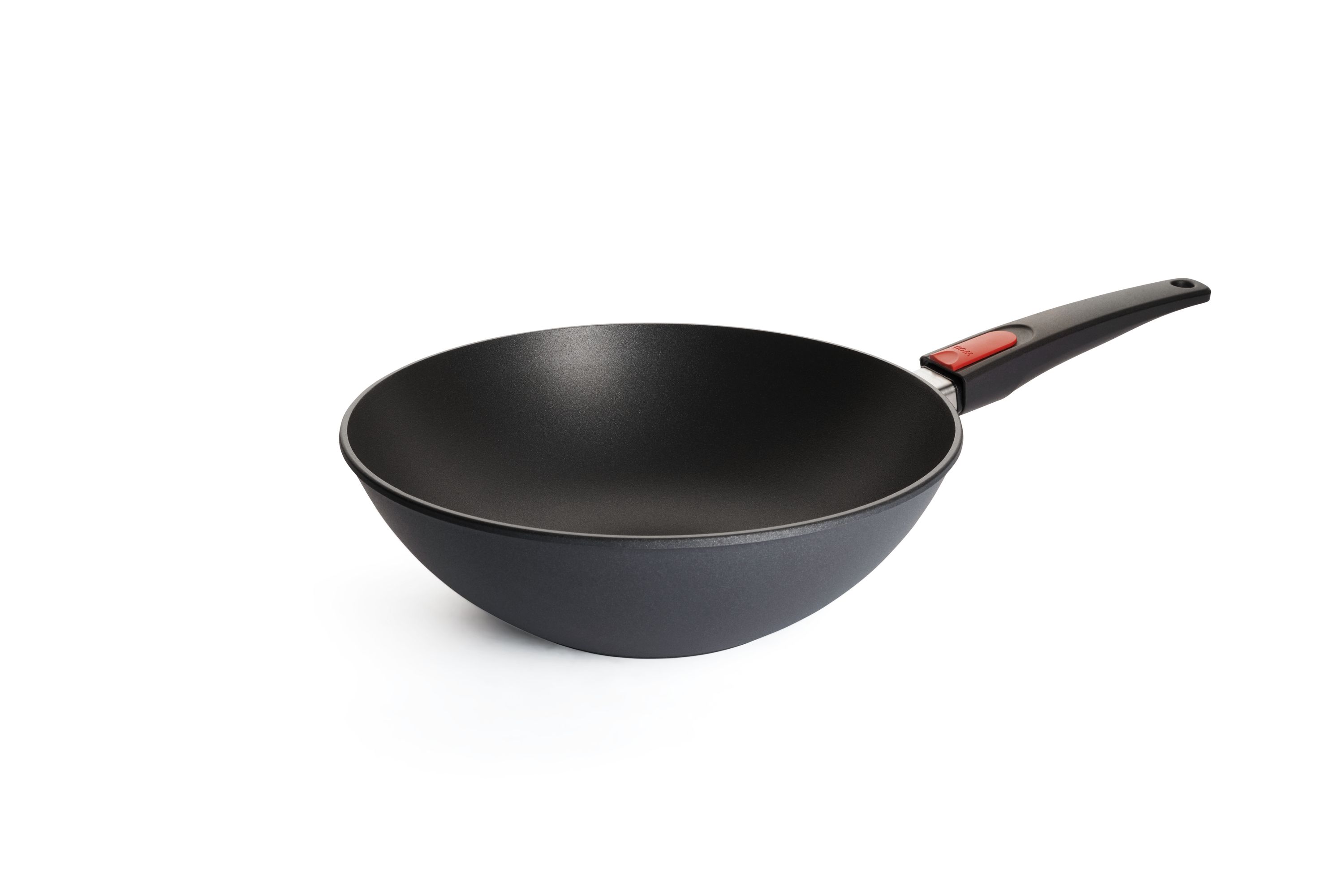 Leere WOLL-Wokpfanne mit Antihaftbeschichtung und ergonomischem Griff mit rotem Knopf, schräg fotografiert.
