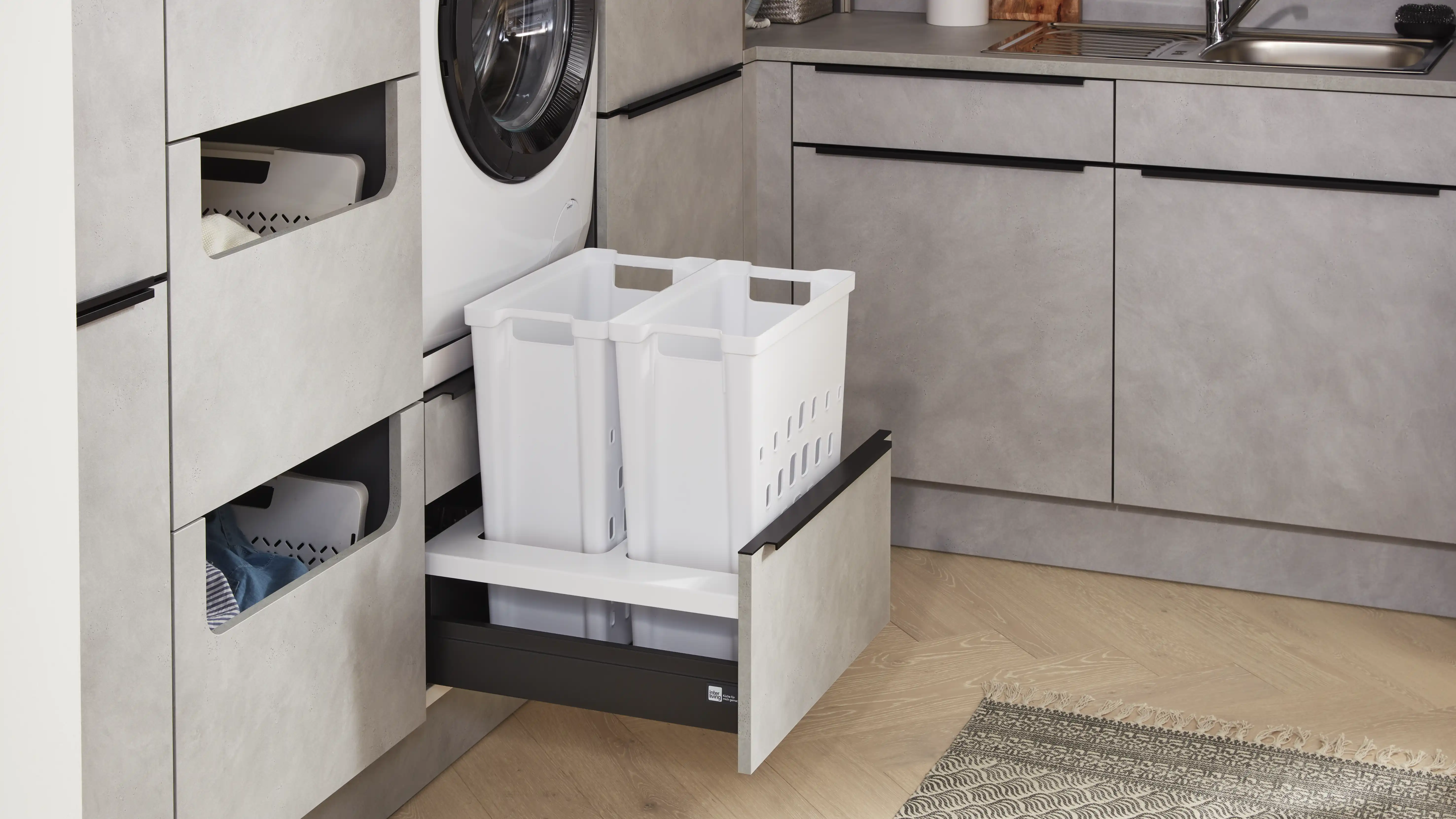 Moderner Hauswirtschaftsraum mit ausziehbarem Wäschekorb-System im grauen Unterschrank