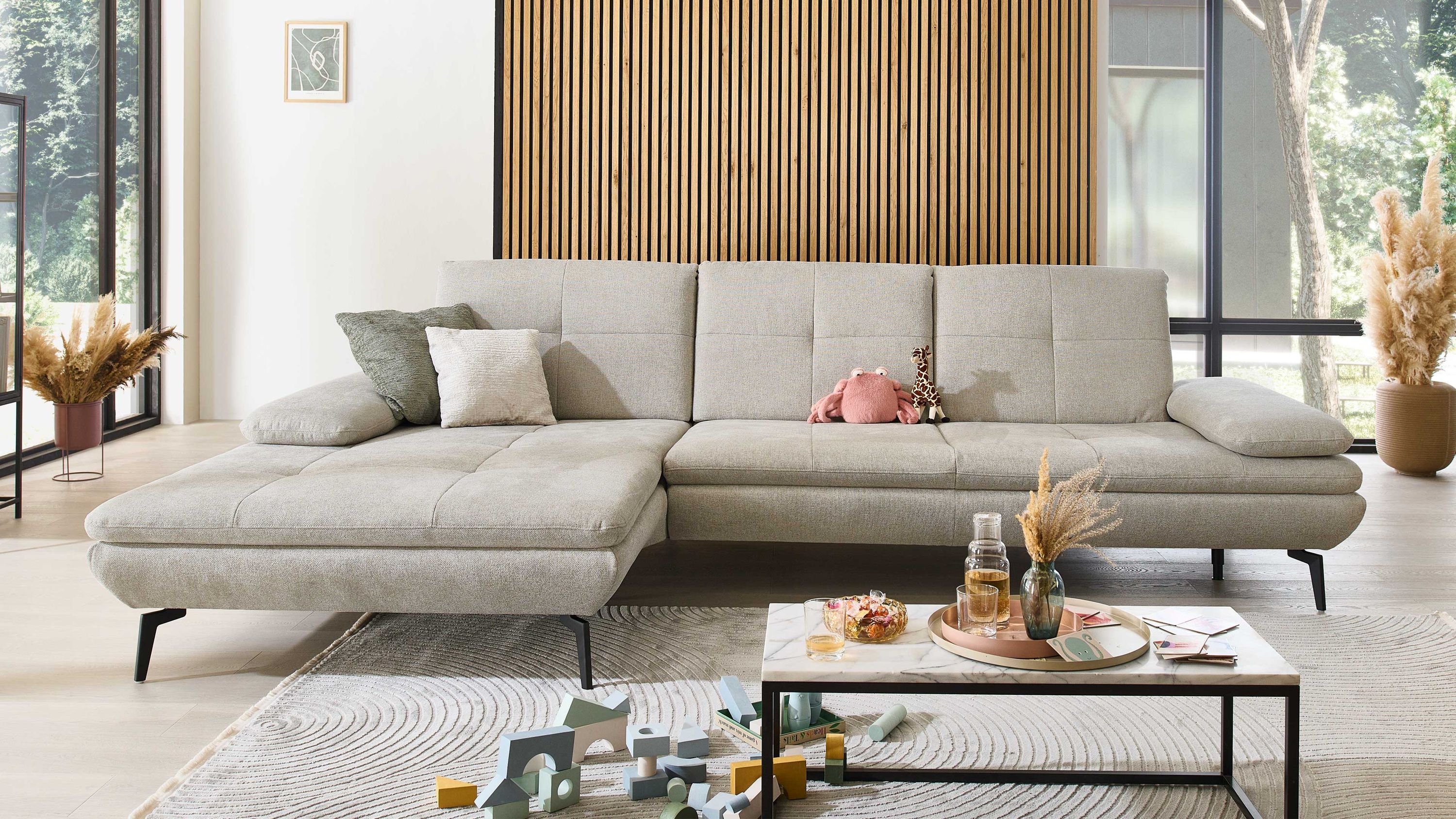 Ecksofa mit ecrufarbenem Flachgewebe und schwarzen Metallfüßen in modernem Wohnzimmer