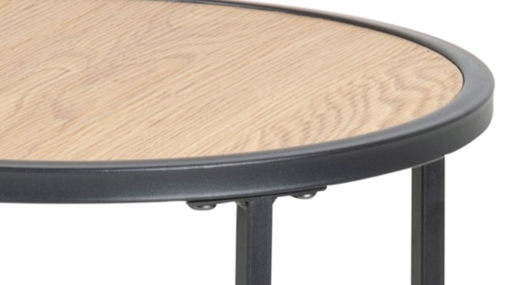 Runder Holztisch mit Metallrahmen – Detailansicht Teilansicht eines runden Holztischs mit schwarzem Metallrahmen und Beinen, aus schräger Perspektive fotografiert.
