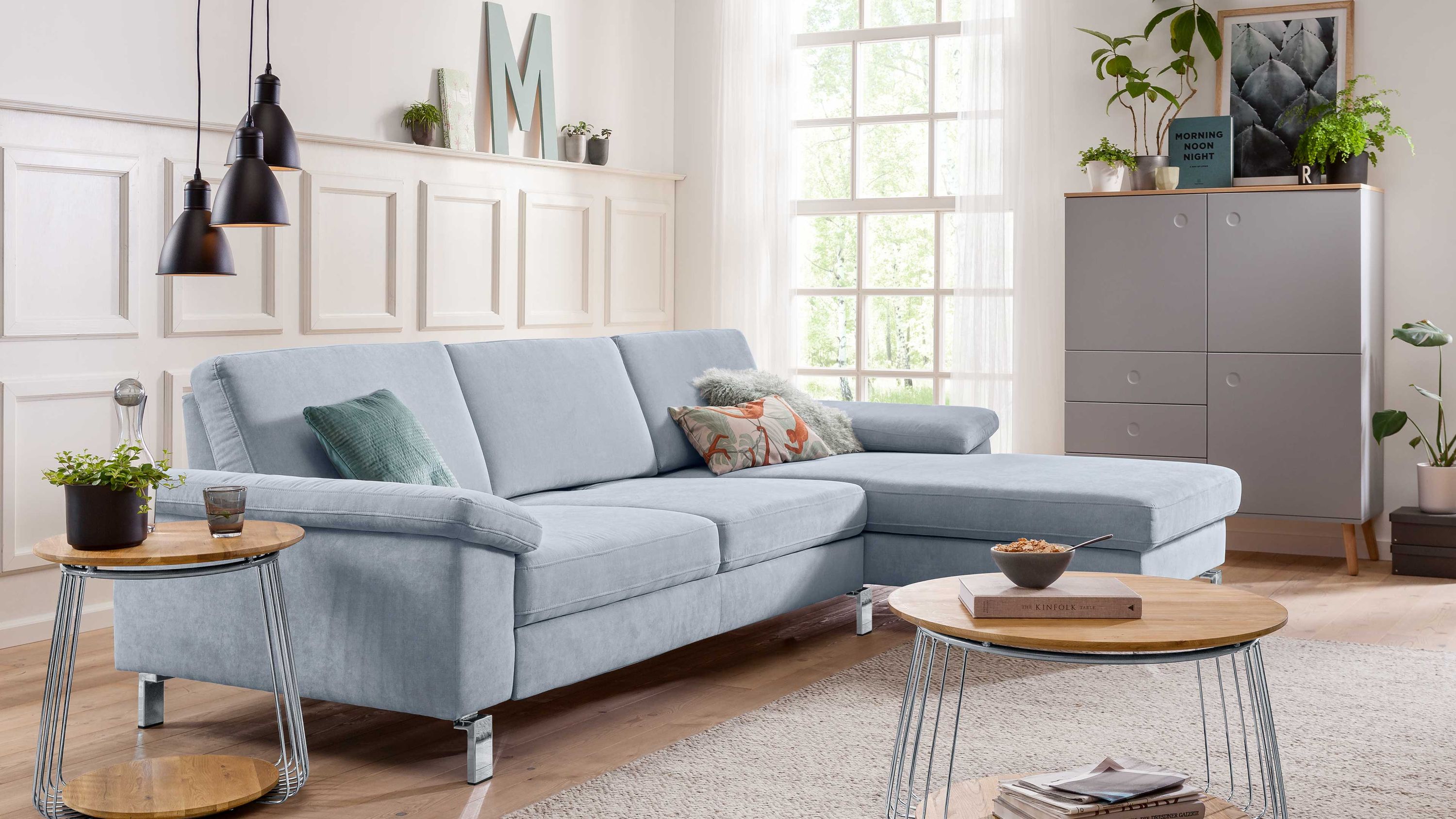 Ecksofa in hellblauem Stoff mit Chromfüßen in modernem Wohnzimmer