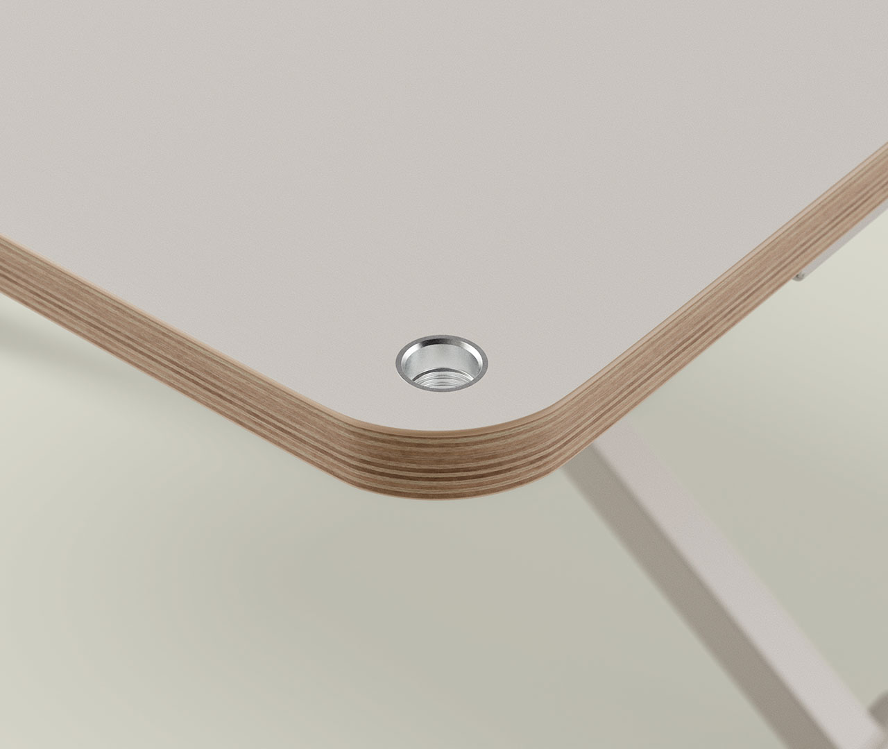 Detail der Tischplatte mit abgerundeter Kante, mehrschichtiger Holzoptik und eingelassener Metallgewindebohrung