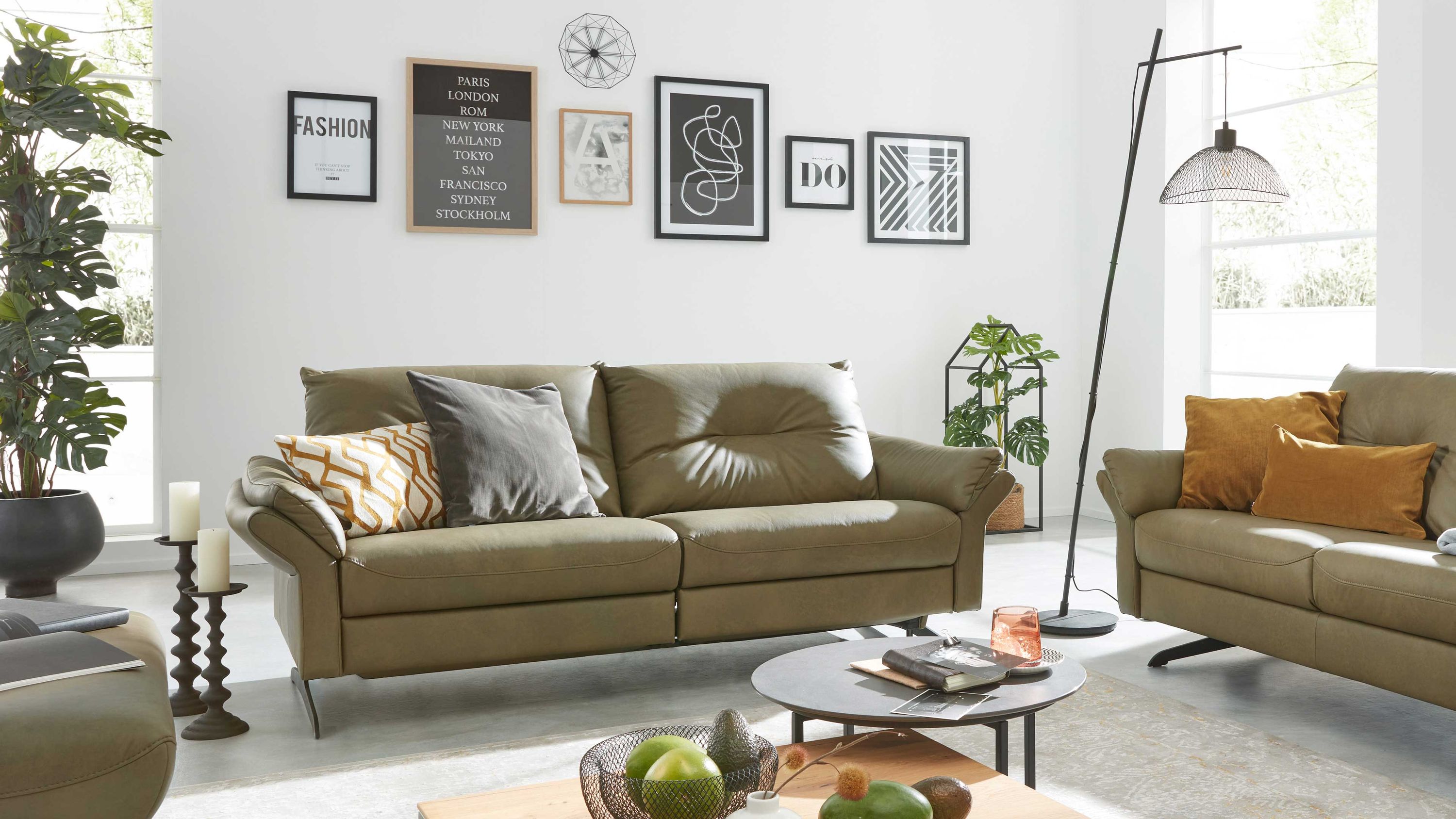 Zweier-Sofa mit olivgrünem Lederbezug und Metallfüßen dekoriert mit Kissen in Grau und Weiß mit Muster