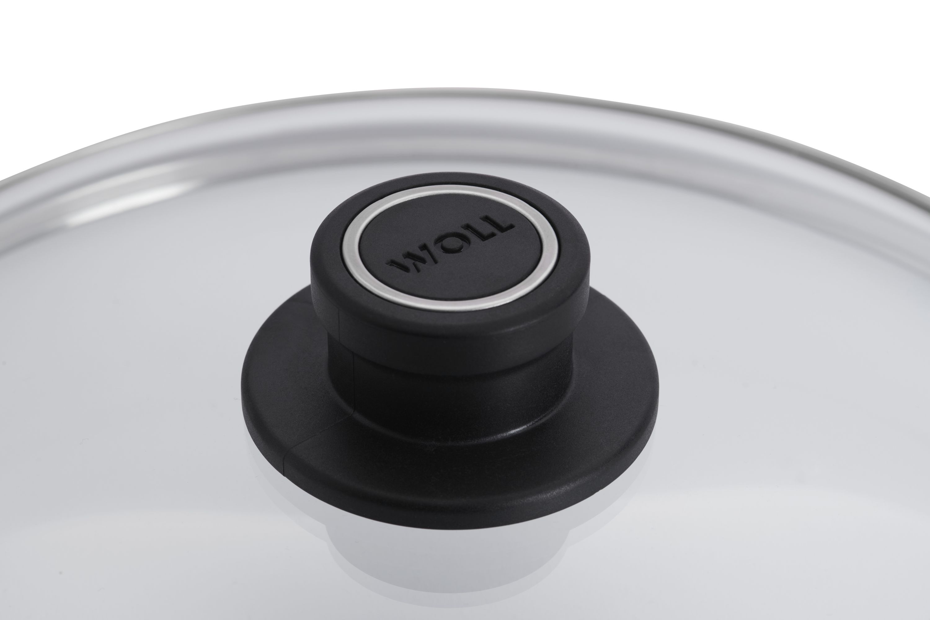 WOLL-Deckelgriff aus schwarzem Kunststoff mit silbernem Ring, auf klarem Glasdeckel.