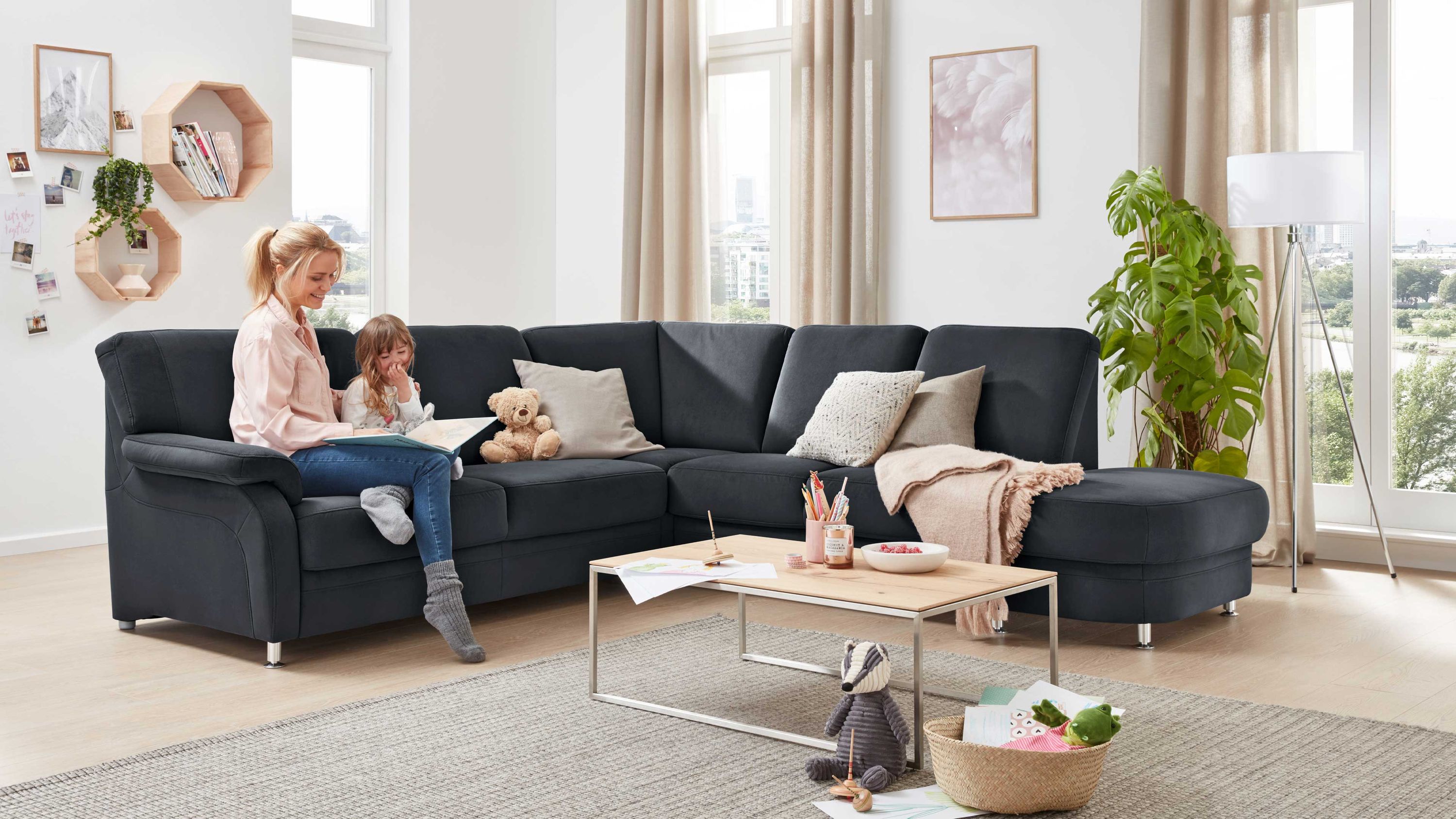 Anthrazitfarbenes Ecksofa mit Metallfüßen Anthrazitfarbenes Ecksofa mit Metallfüßen in hellem Wohnzimmer mit Teppich und Couchtisch