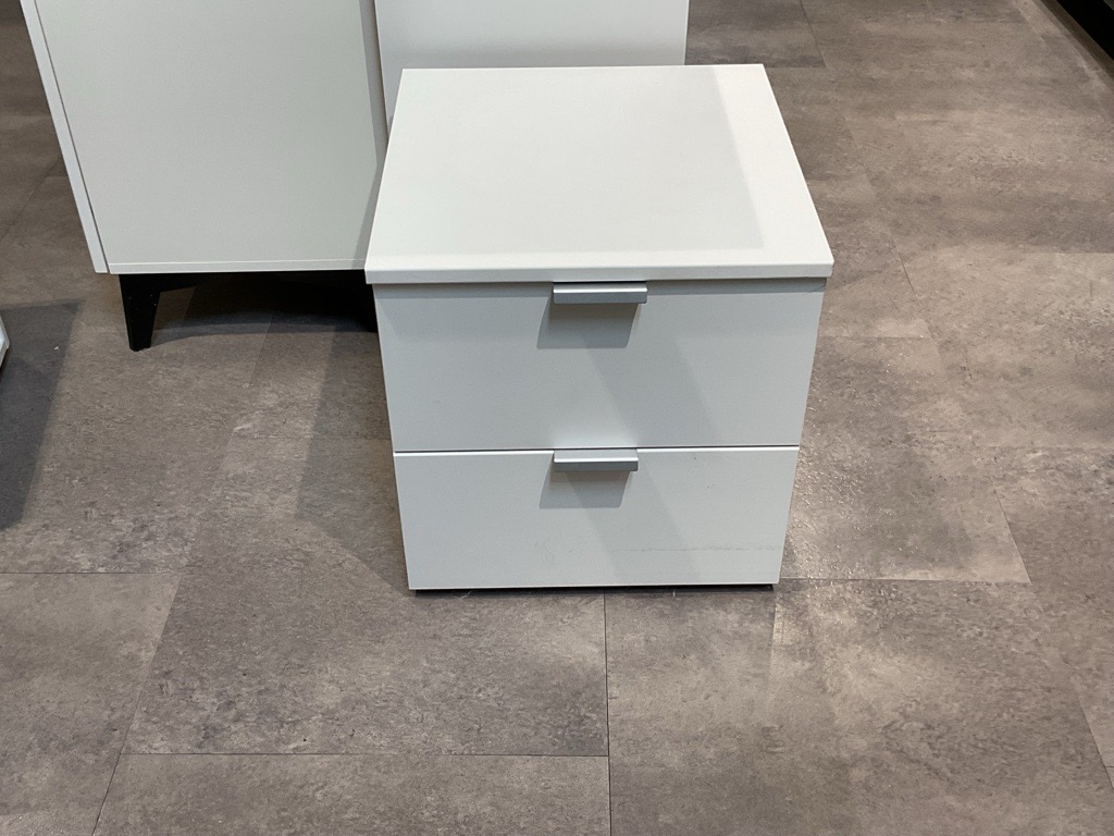 Weiße quadratische Kommode mit zwei Schubladen und glatter matter Oberfläche.