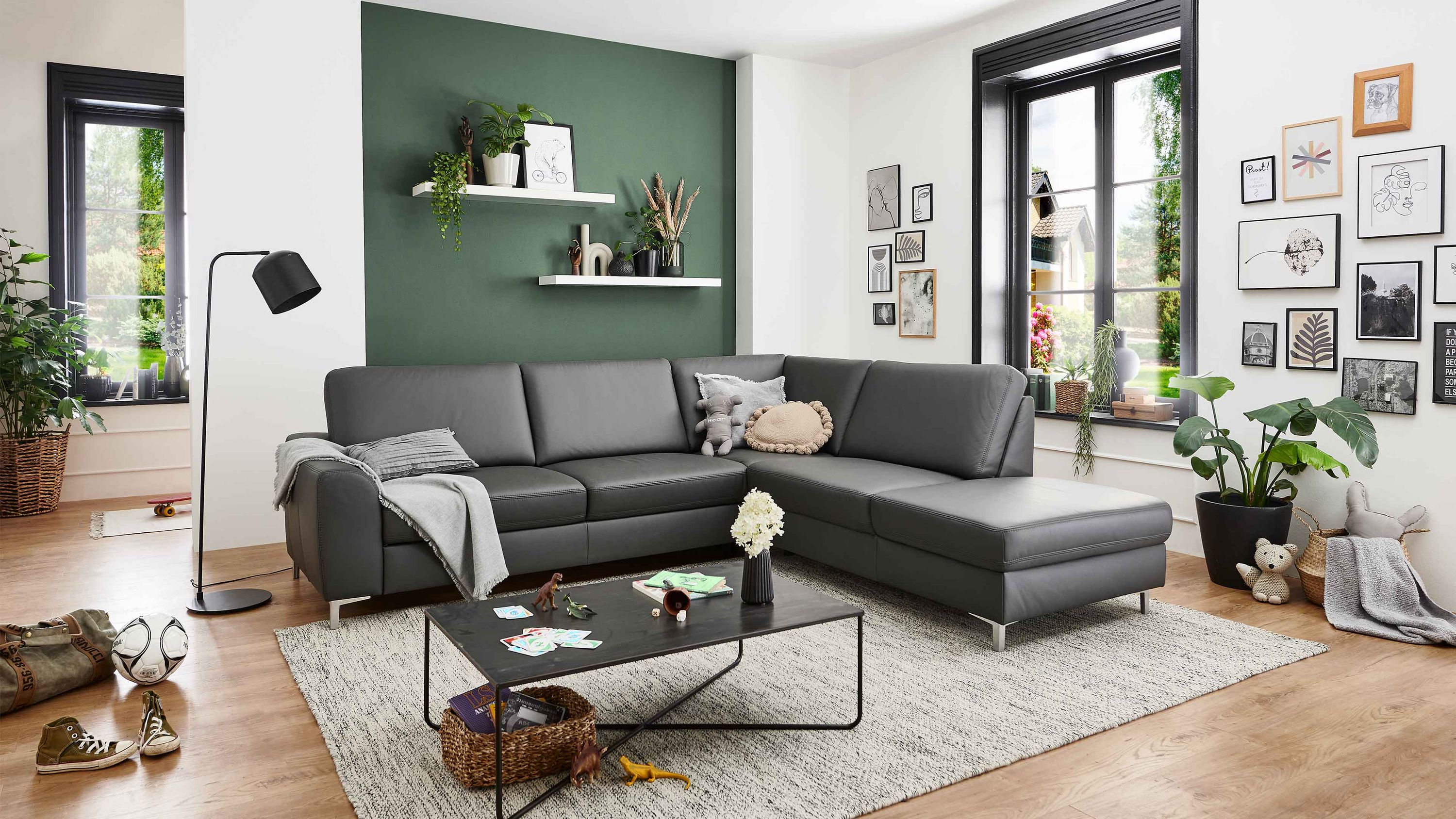 Anthrazitfarbenes Ecksofa mit Metallfüßen Anthrazitfarbenes Ecksofa mit glatten Polstern und Metall-Winkelfüßen in modernem Wohnzimmer