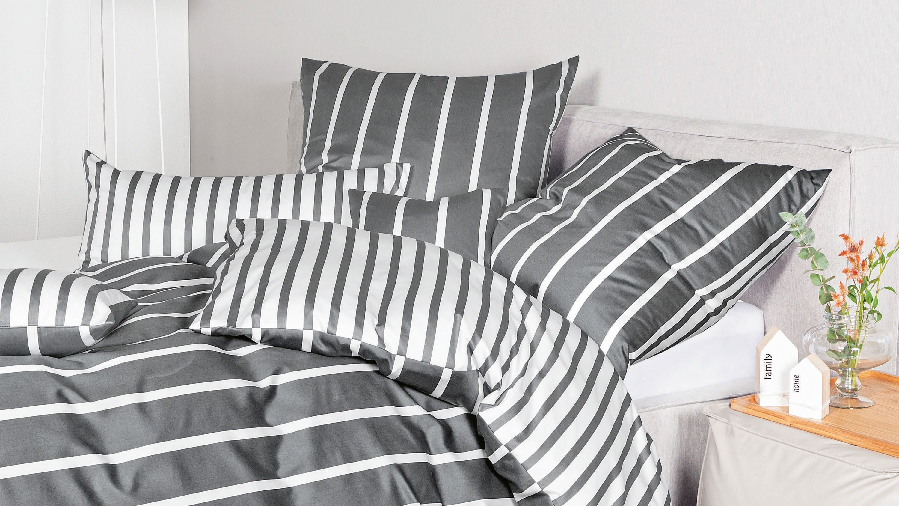 Bett mit Bettwäsche-Set in anthrazit und weiß mit Streifenmuster