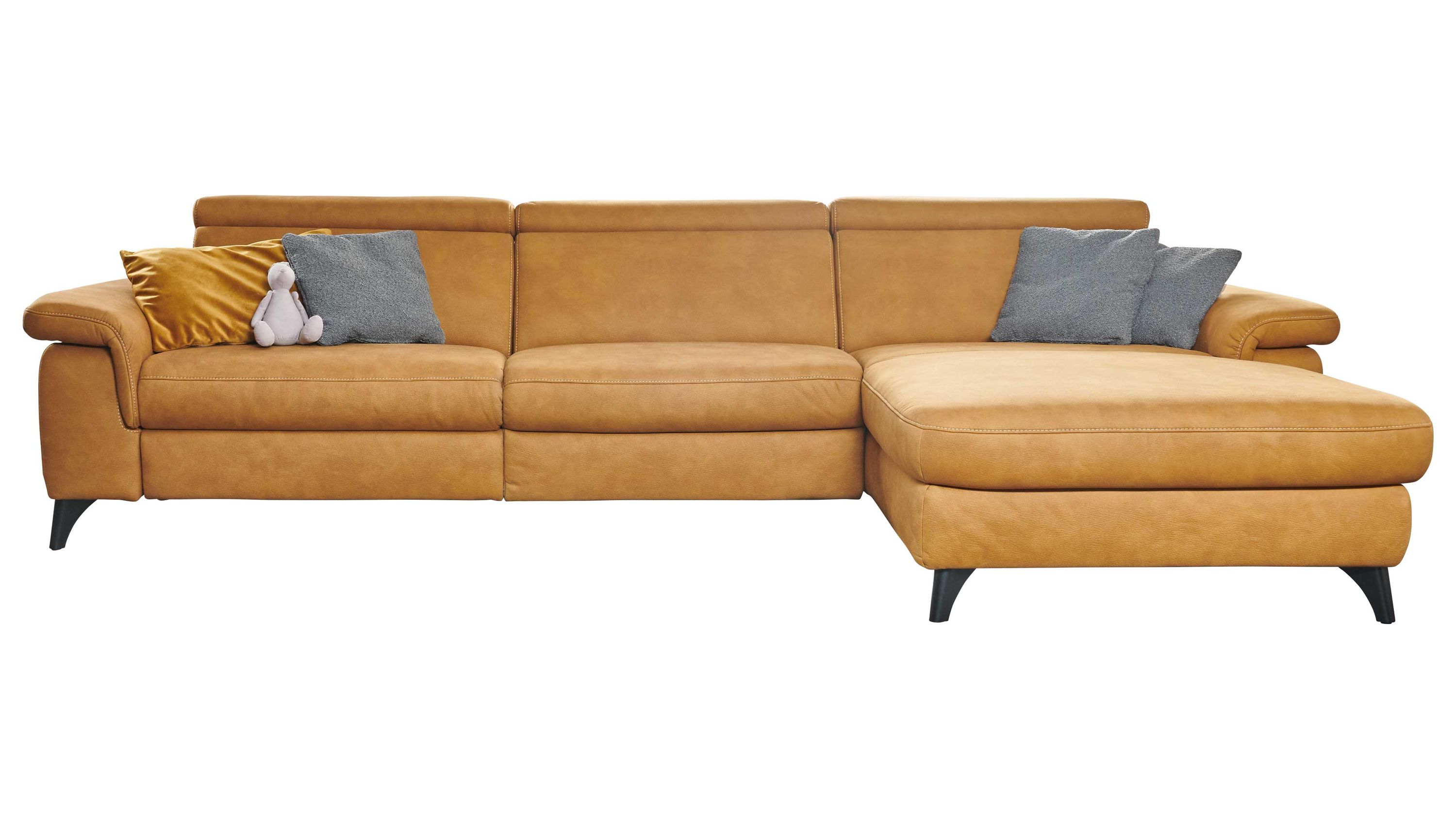 Ecksofa mit verstellbaren Kopfstützen in ockergelber Farbe mit schwarzen Füßen und mehreren Kissen