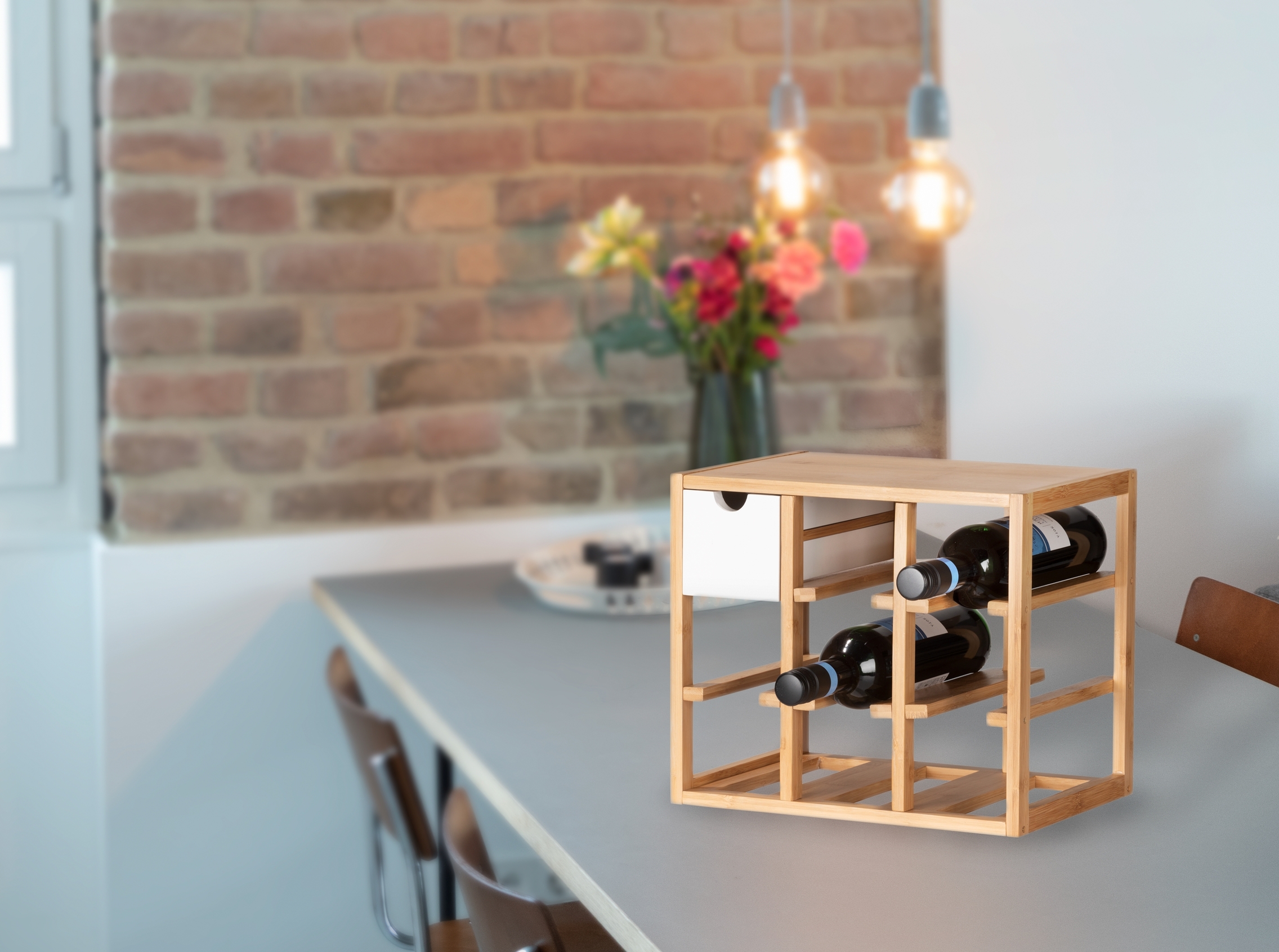 Quadratisches Weinregal mit Flaschenfächern Quadratisches Bambus-Weinregal mit Flaschen auf Tisch vor Backsteinwand hängende Leuchten leicht schräg von rechts