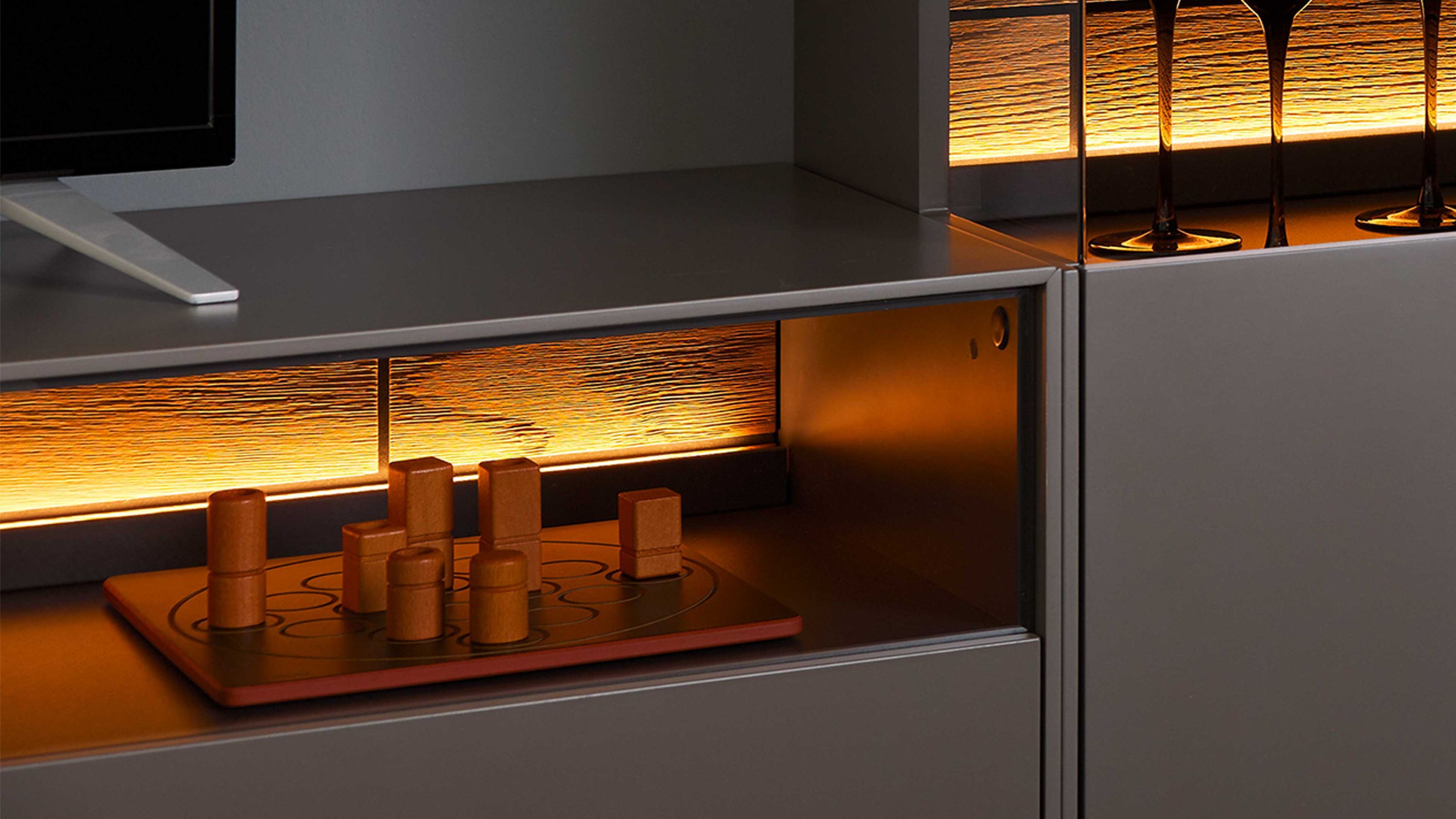Zweiteiliges Wohnzimmermöbel mit LED-Beleuchtung und Holzspiel auf offener Ablage