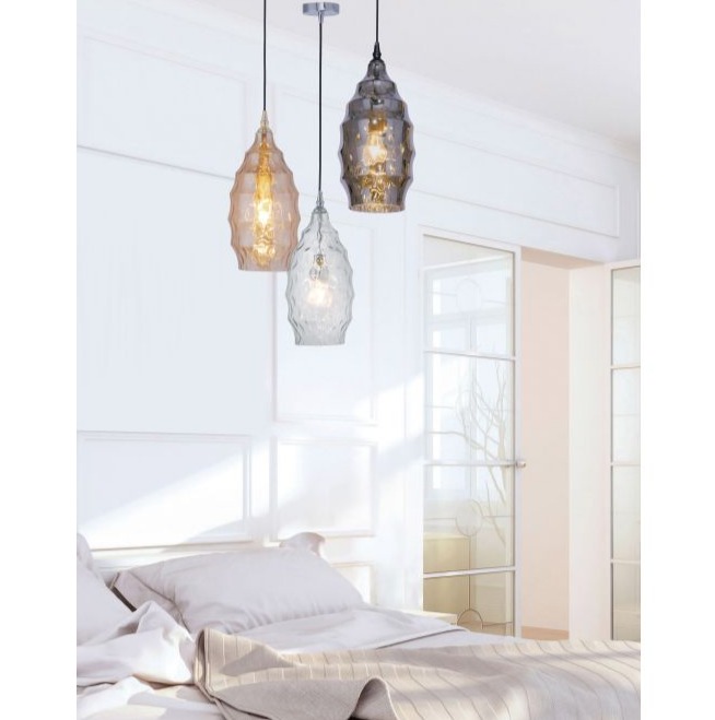 Drei Pendelleuchten mit ovalen Glasschirmen über einem Bett mit Kissen leicht schräge Ansicht im Innenraum installiert