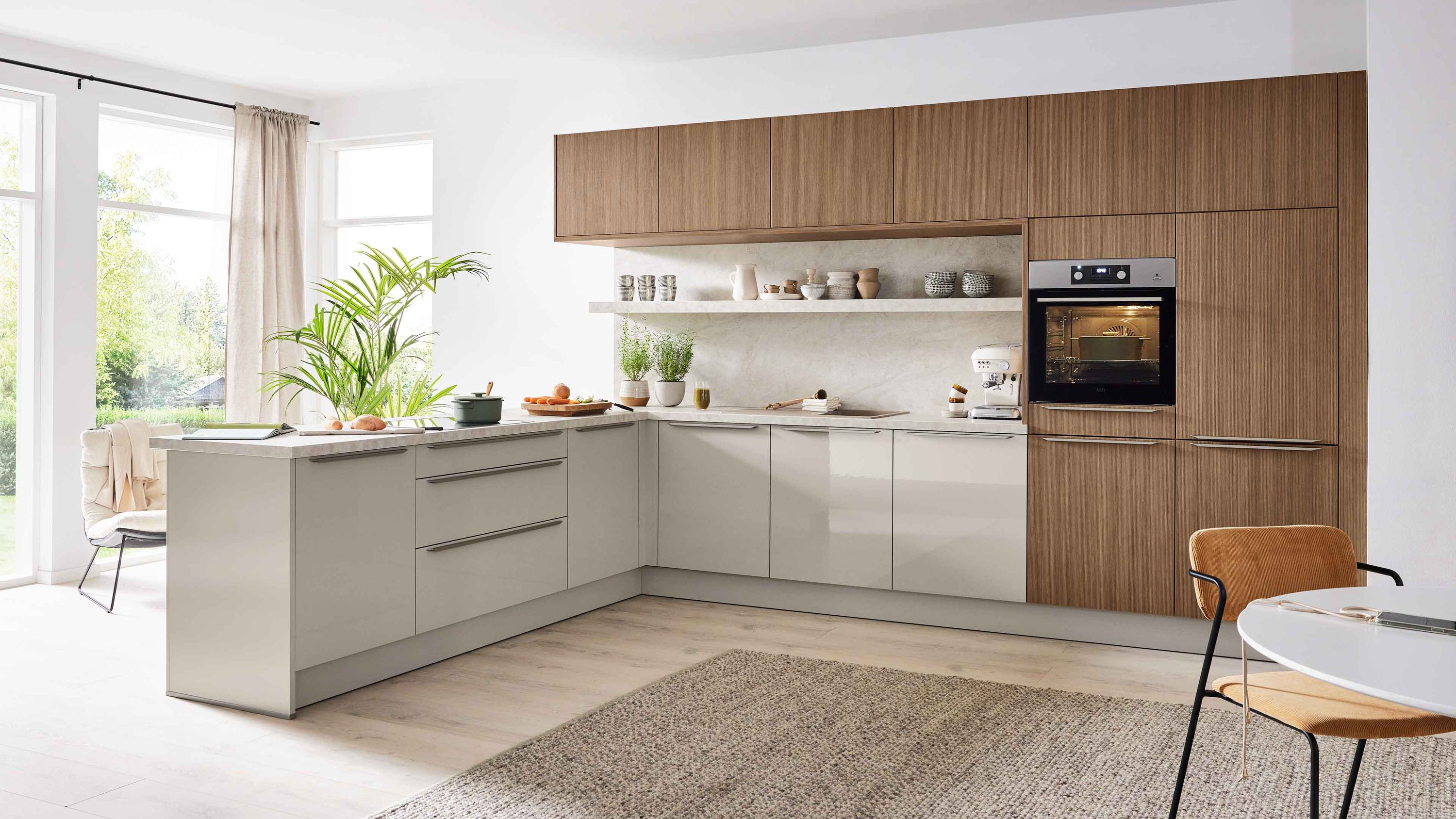 Zweifarbige L-Küche in Beige und Holzoptik mit grifflosen Fronten Hängeschränken Einbauofen und heller Raumgestaltung.