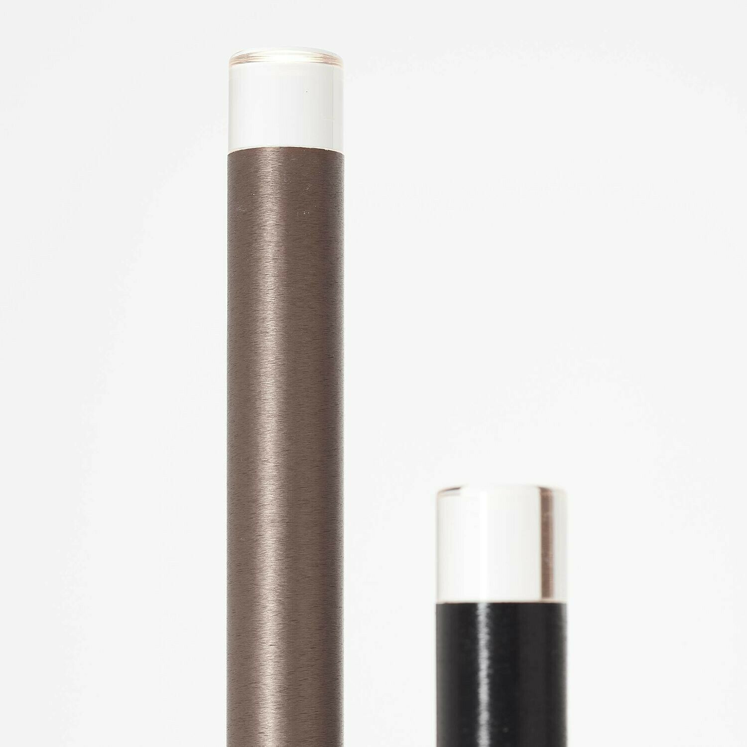 Zwei zylindrische Stehleuchten in Braun und Silbergrau mit weißem Lichtkopf  modernes Design