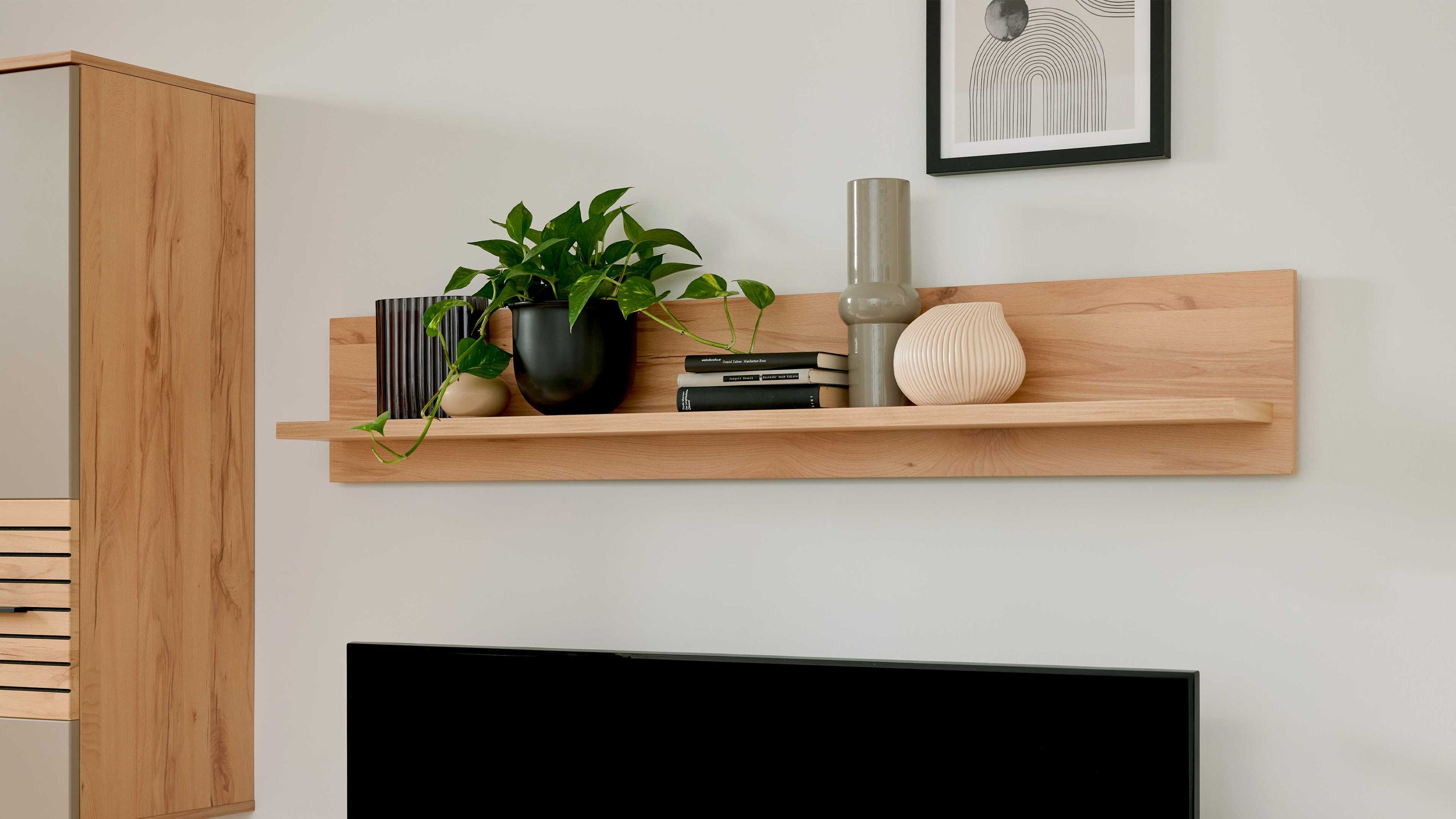 Wandboard aus hellem Holz mit Rückwand darauf Pflanzen Bücher und Vasen in verschiedenen Farben