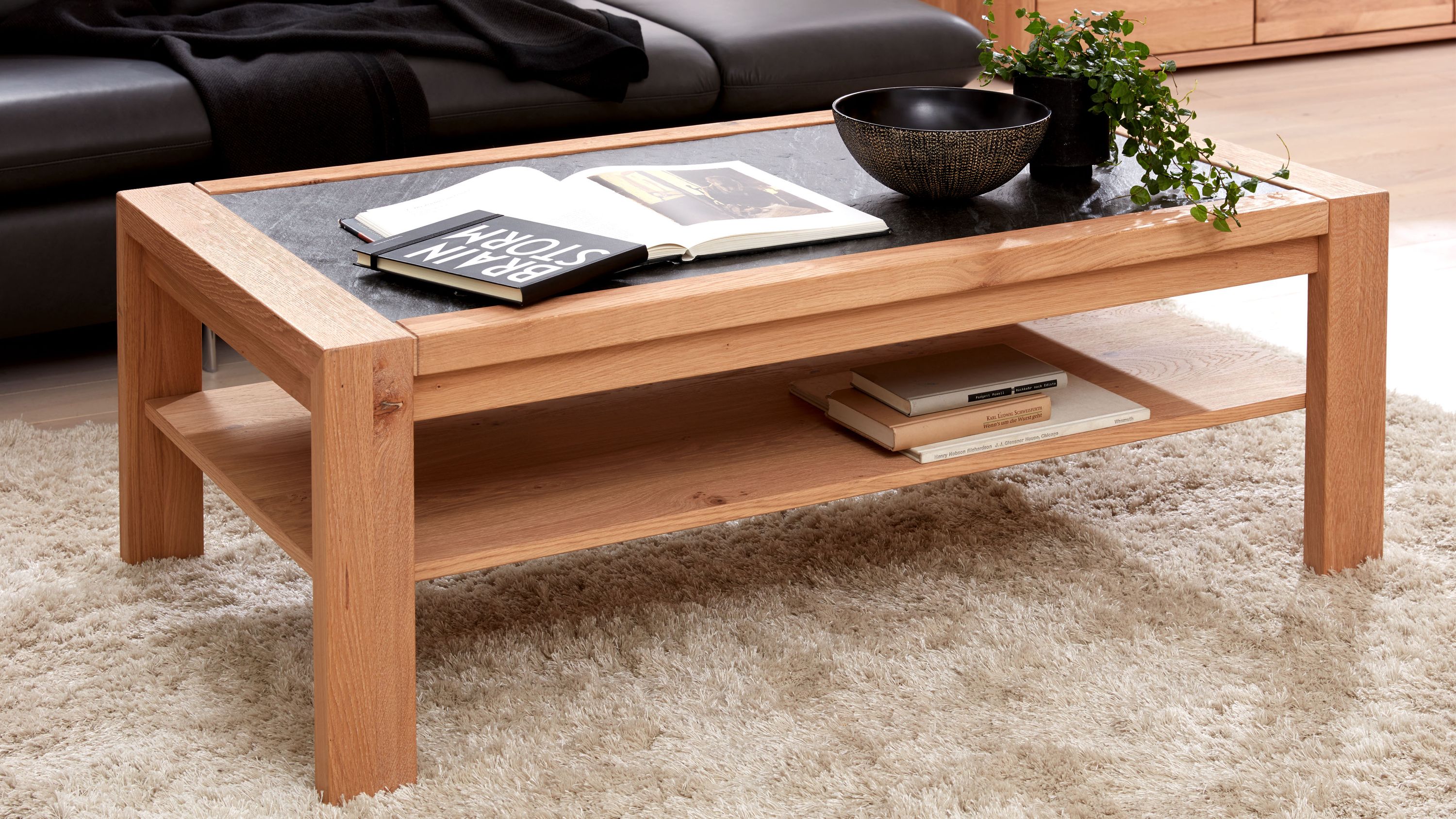 Couchtisch mit Holzgestell und dunkler Tischplatte Rechteckiger Couchtisch mit hellbraunem Holzgestell und dunkler Tischplatte mit Ablagefläche darunter