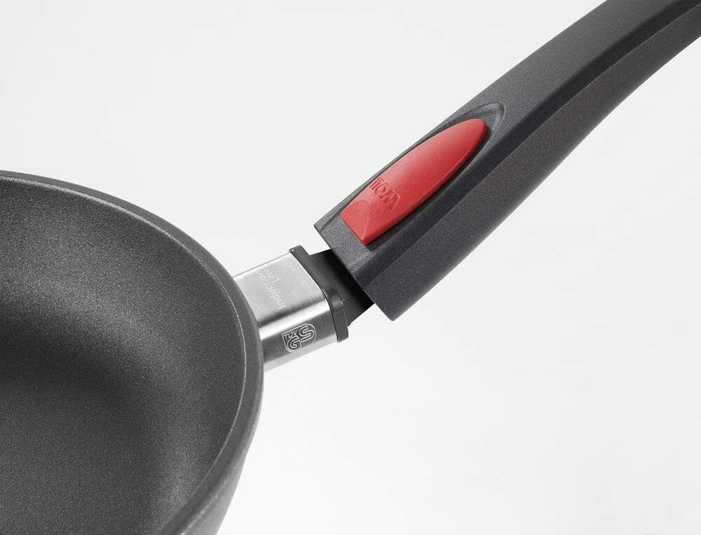 Detailaufnahme seitlich von Griff und rotem Entriegelungsknopf an der viereckigen Gusspfanne