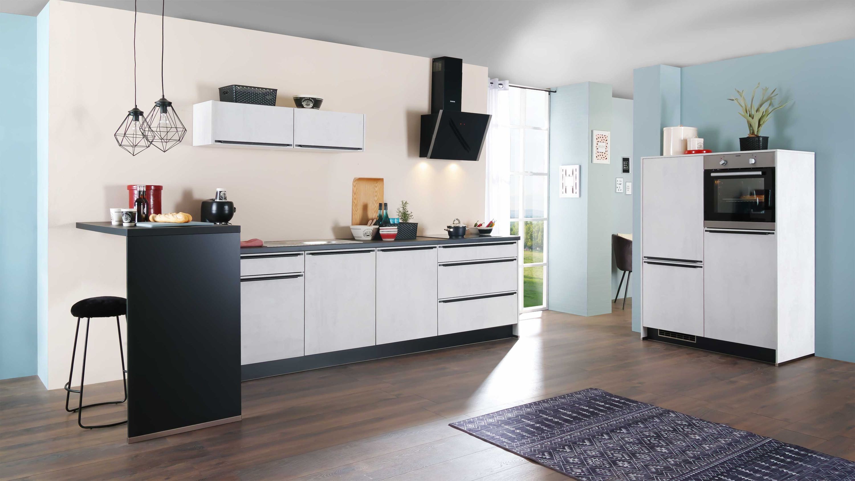 Weiße Küche mit schwarzer Platte Holzfußboden Barhocker Edelstahlgeräten blauer Wand Tageslicht Deko.