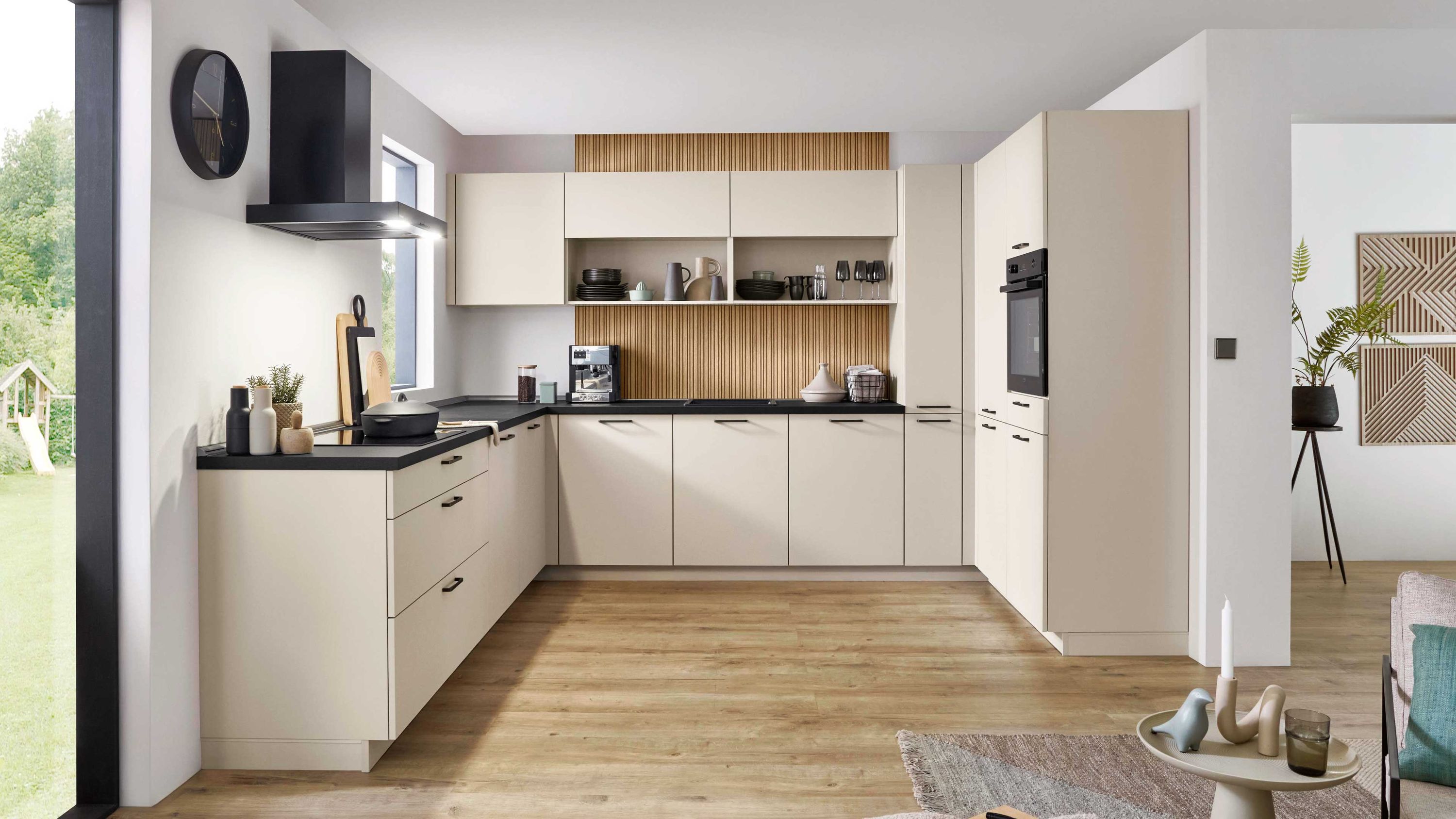 Helle Küche mit Holzdetails und Durchgang Helle Fronten schwarze Arbeitsfläche Einbaugeräte; Holzfußboden Dunstabzug offener Durchgang mit Möbeln