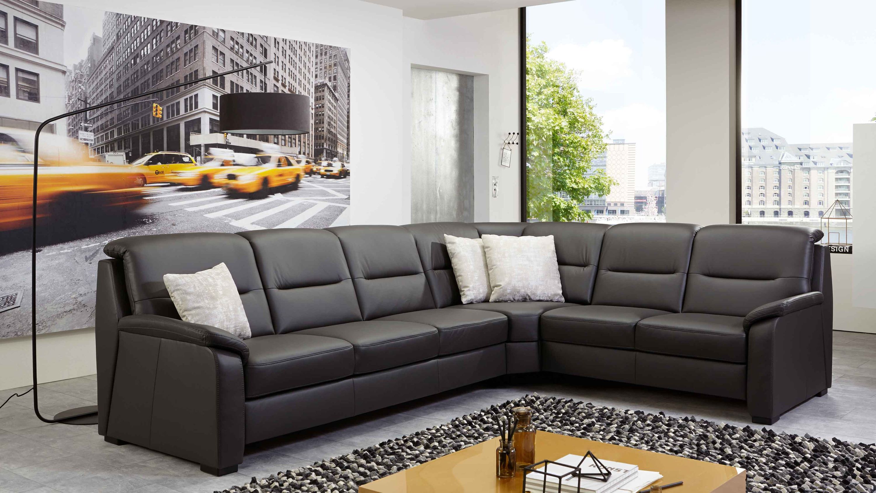 Anthrazitfarbenes Ecksofa mit Lederbezug und Holzfüßen Ecksofa mit anthrazitfarbenem Lederbezug und schwarzen Holzfüßen in modernem Wohnzimmer