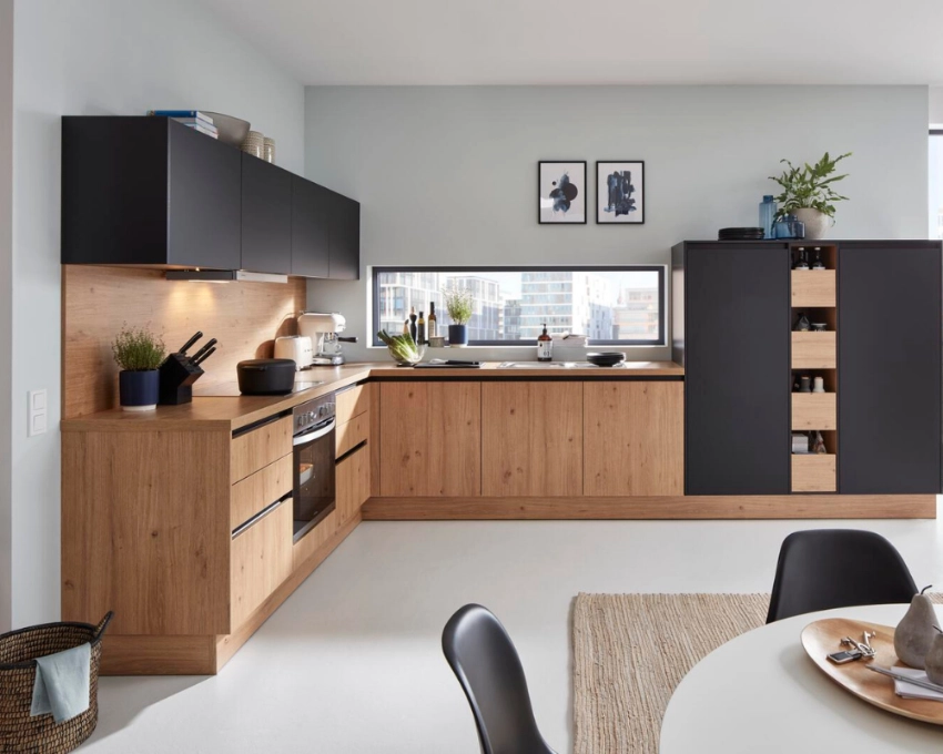 Küchenzeile in Holz-Schwarz-Kombination Küchenzeile mit Holzfronten und schwarzen Elementen, integrierter Herd und offene Gestaltung mit Esstisch