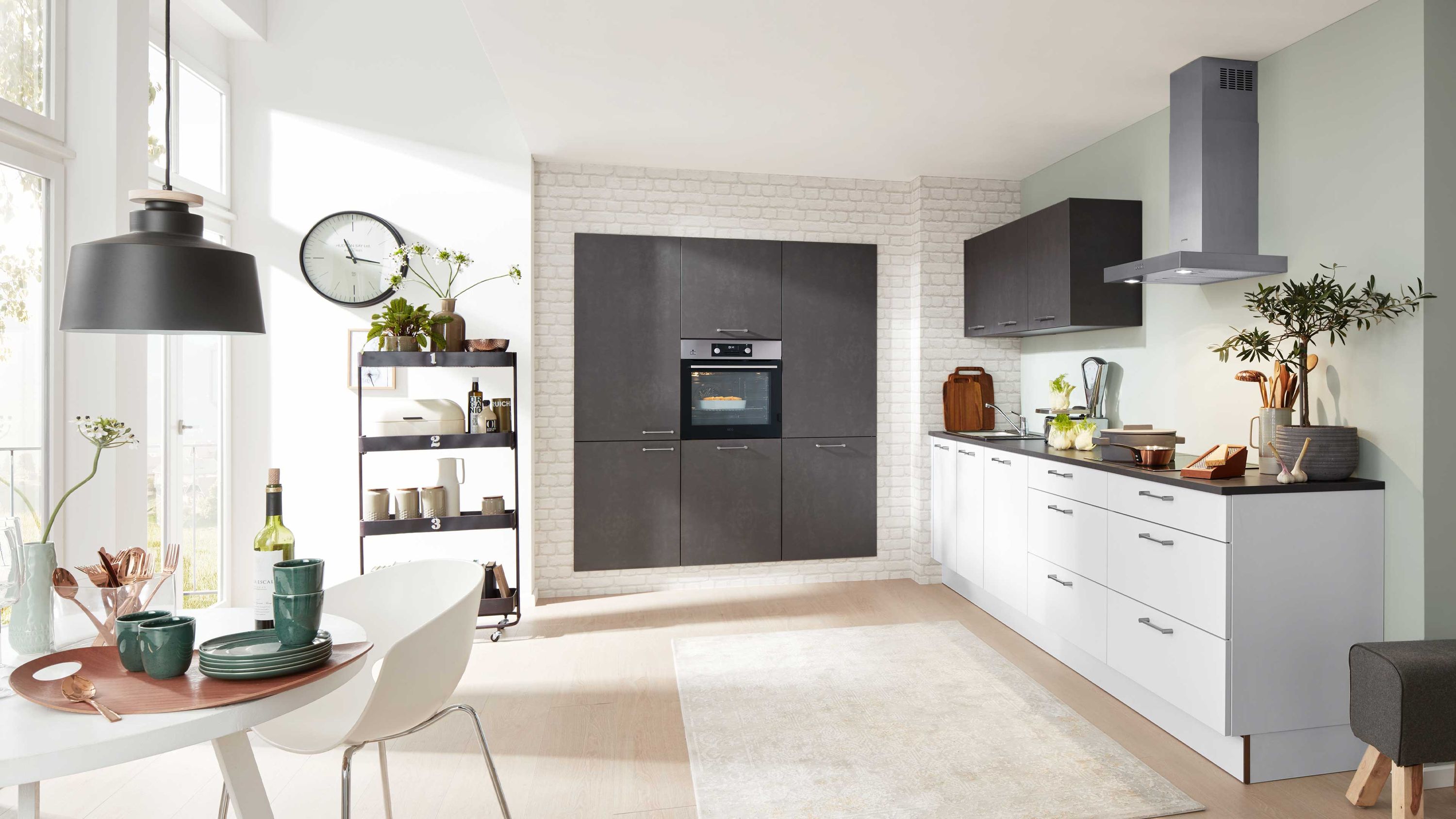 Küche mit Essbereich und hellem Designkontrast Helle Schränke dunkle Hochschränke integrierter Ofen gedeckter Tisch Fensterlicht Pflanzen und Küchenaccessoires