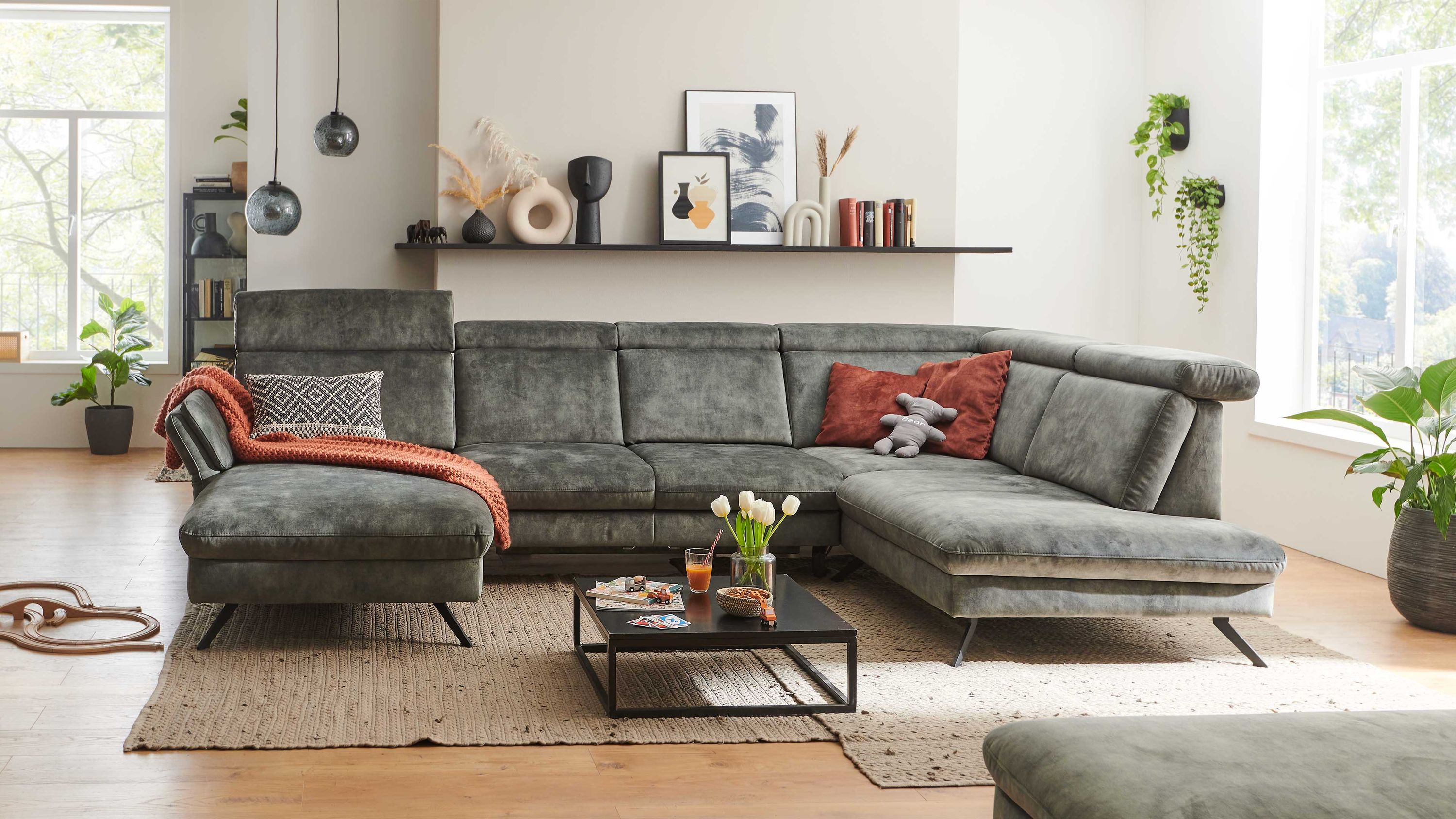 Wohnlandschaft mit moosgrünem Velours und Metallfüßen Wohnlandschaft mit moosgrünem Veloursbezug verstellbaren Rückenlehnen und schwarzen Metallfüßen im Wohnzimmer
