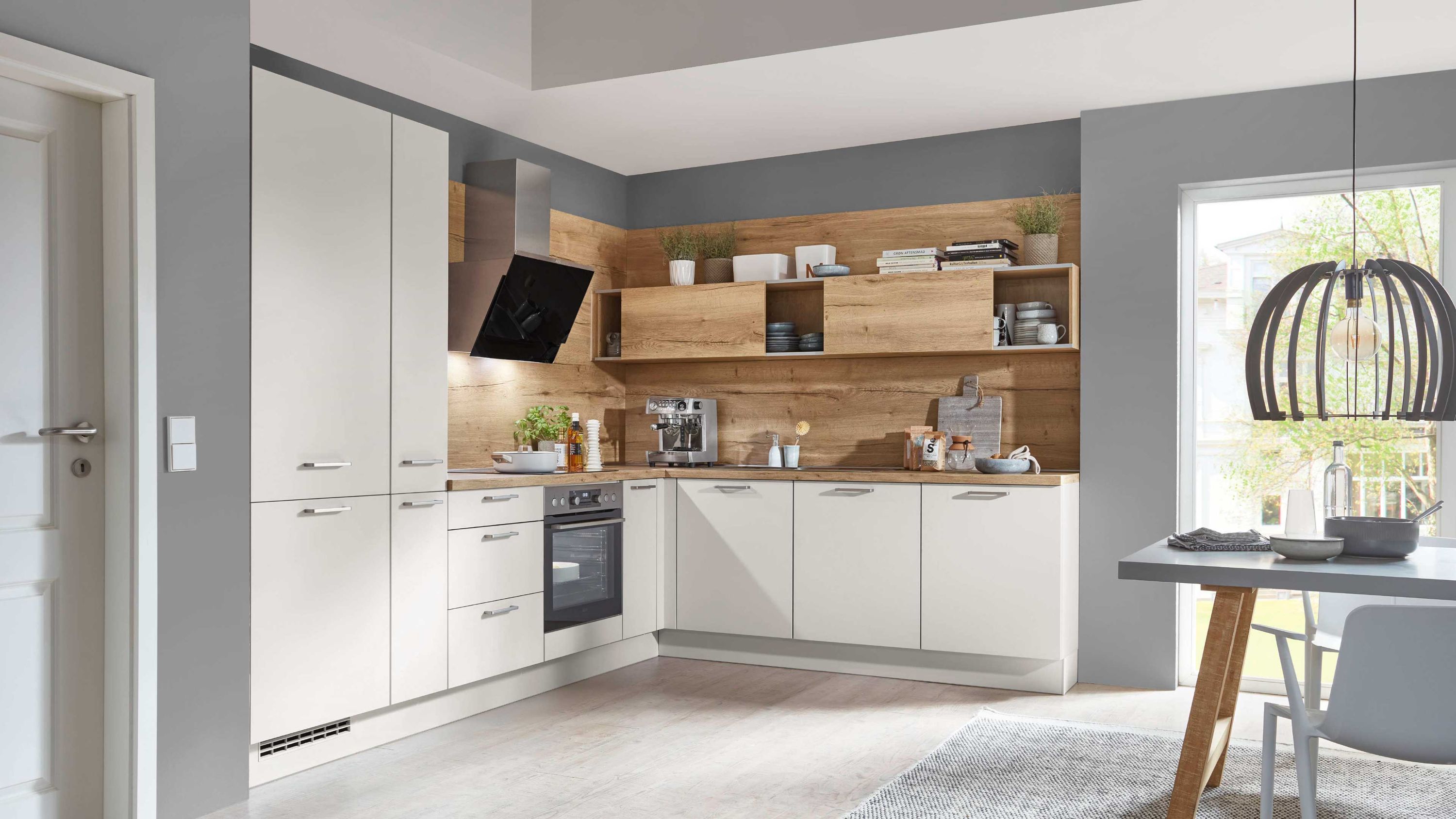 Helle Küche mit Holzdetails und offenem Essbereich Helle Fronten Holzakzente Einbauofen offene Regale Esstisch Fensterlicht Küchenutensilien