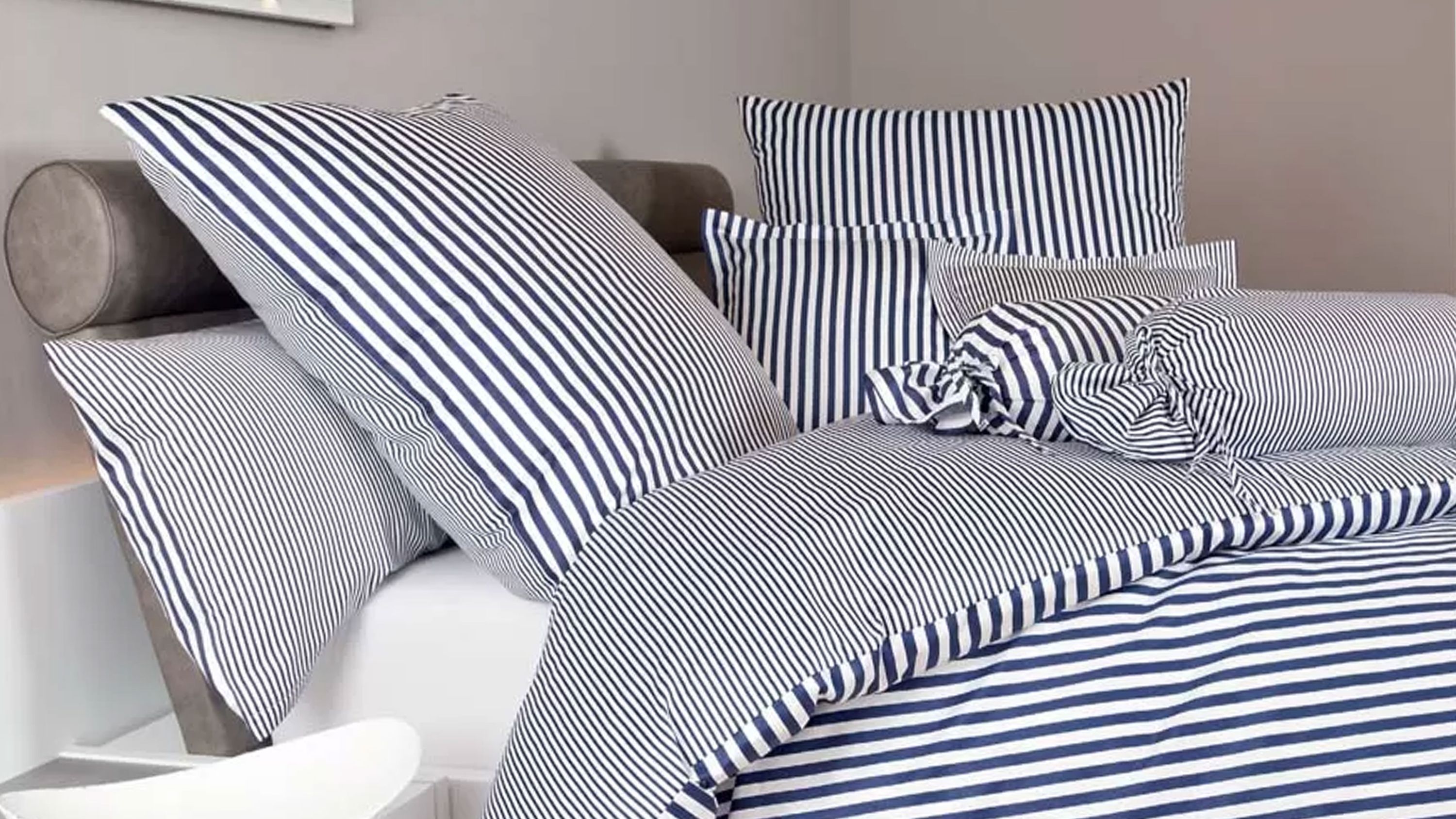 Bettwäsche-Set mit dunkelblauen und weißen Streifen auf Kissen und Decke