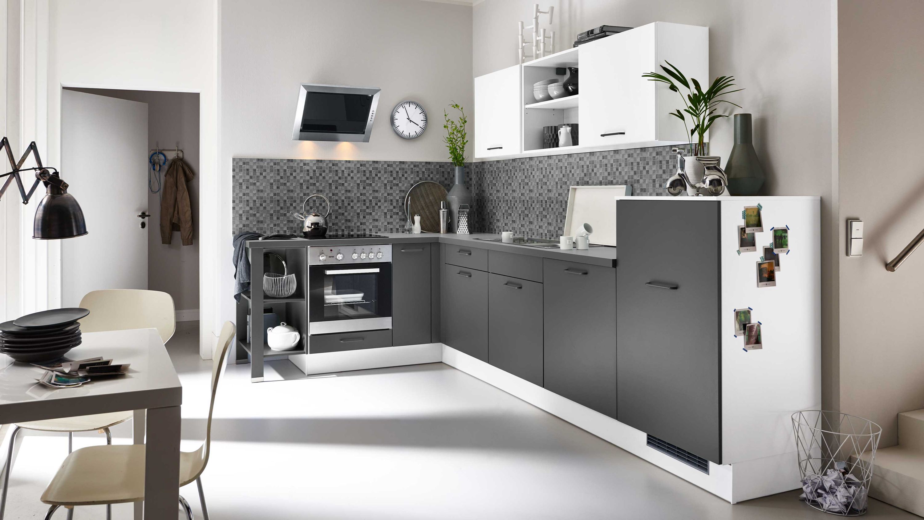 Schwarz-weiße Küche mit Designrückwand. Stilvolle Küche in Schwarz-Weiß mit gemusterter Rückwand und klarer Linienführung.
