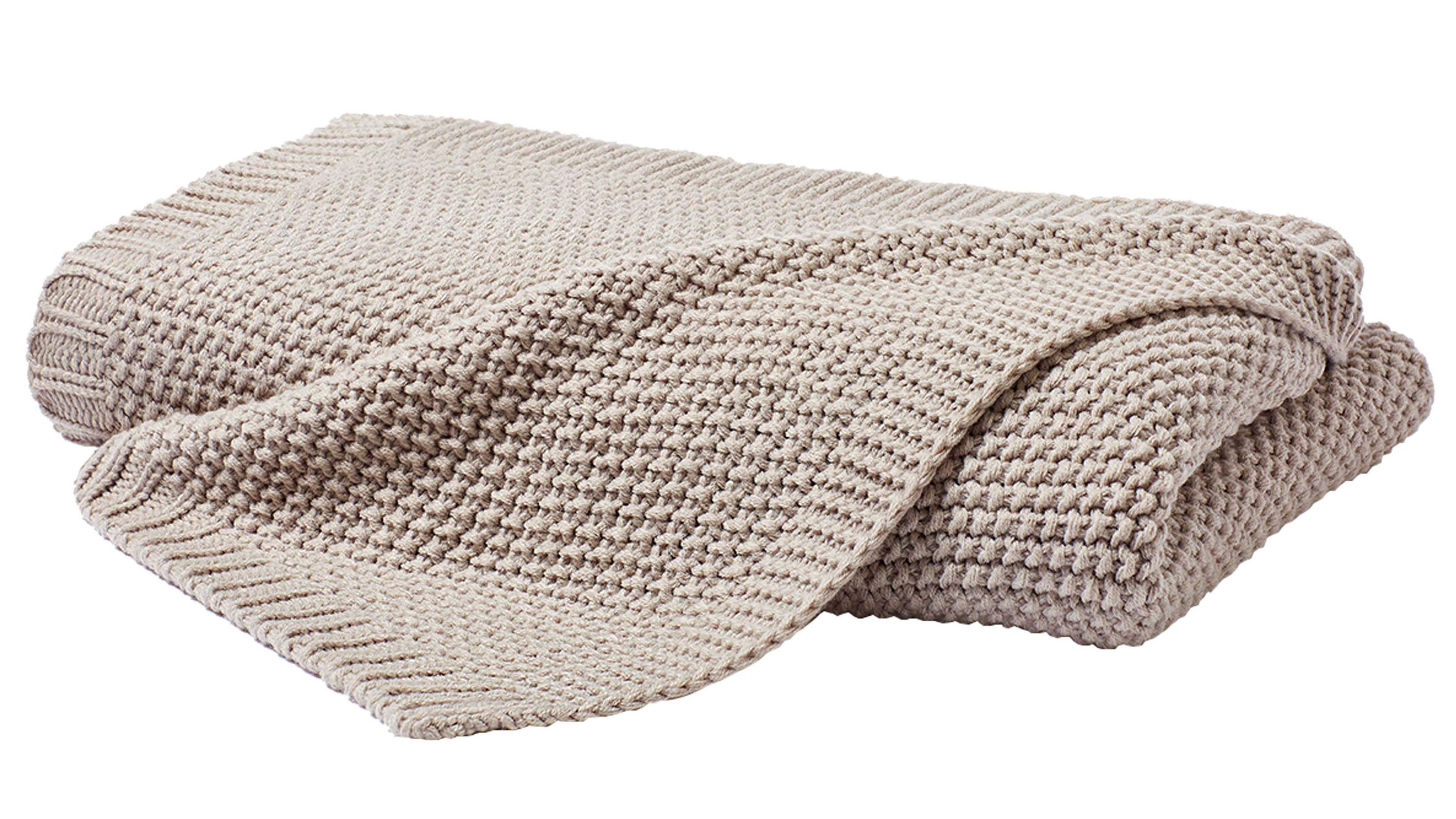 Gefaltete naturfarbene Strickdecke mit grobem Muster