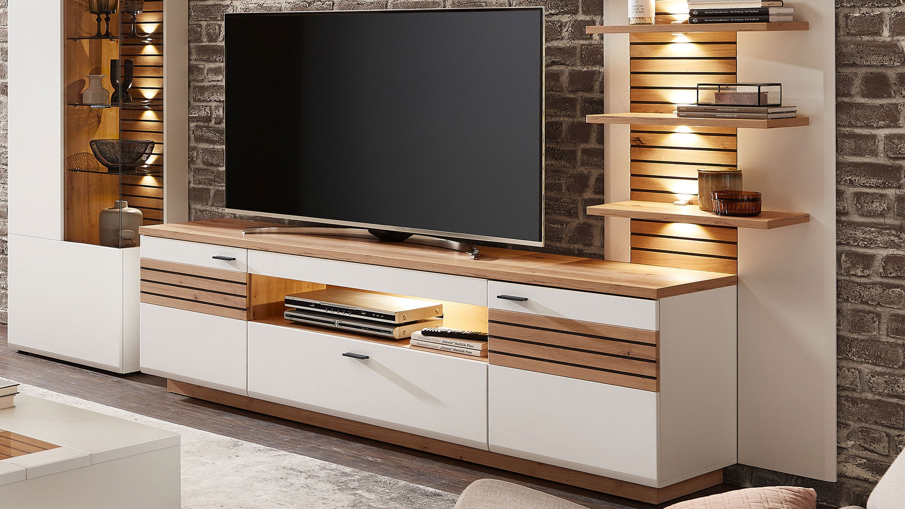 Medienschrank in Weiß und Holz mit Türen und Schublade Medienschrank mit zwei weißen Türen einer Schublade und Holzablagefläche offene Fächer mit Beleuchtung