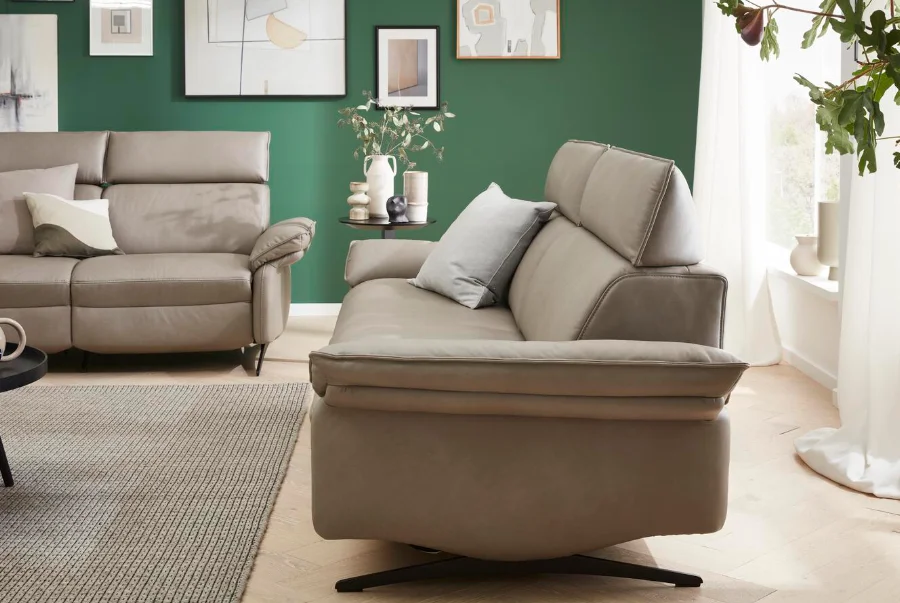 Beiges Relaxsofa in elegantem Wohnzimmer mit grüner Akzentwand und Deko