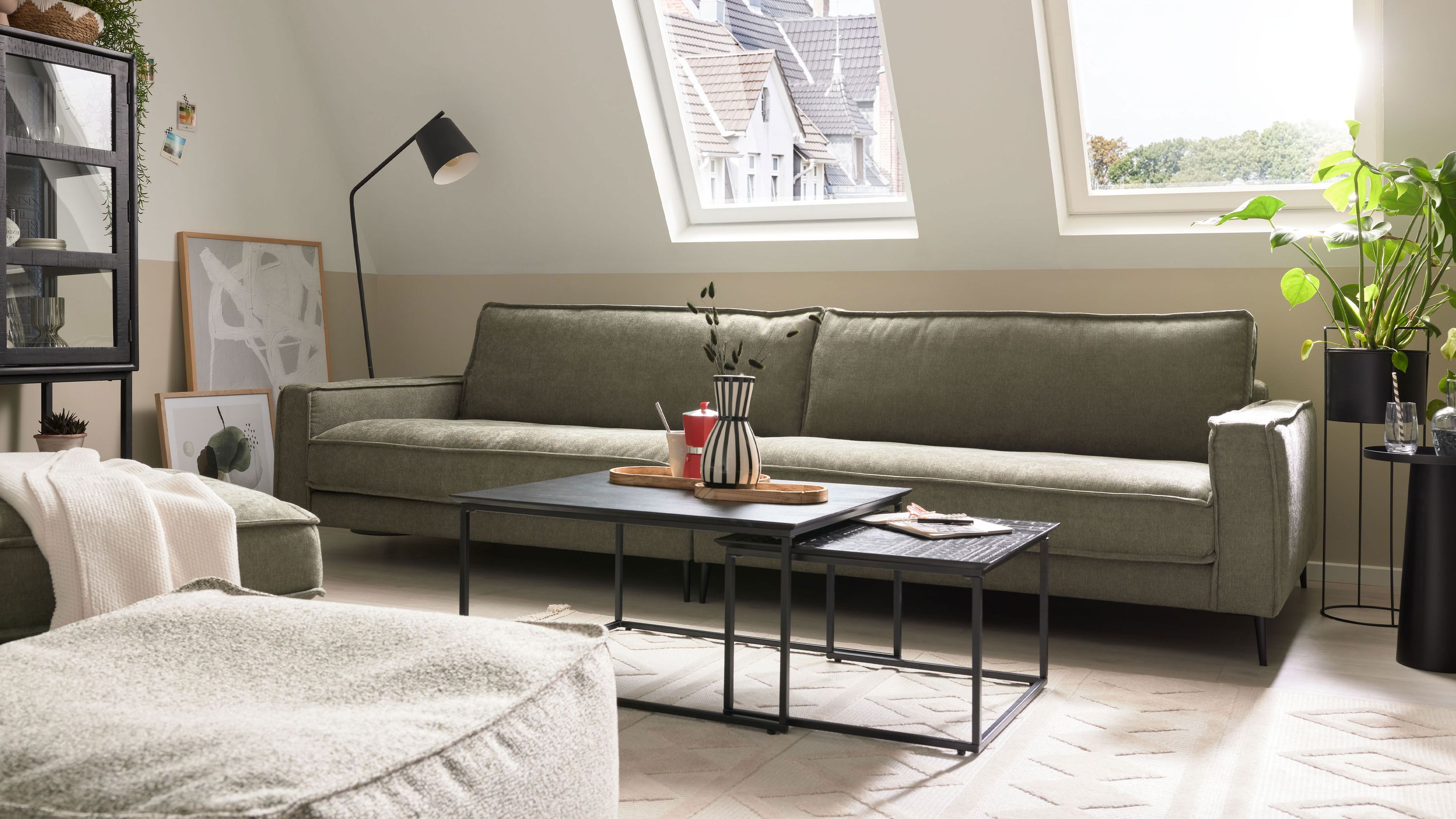 Zweisitziges Sofa mit grünem Strukturbezug und Metallfüßen in hellem Wohnzimmer unter Dachfenstern