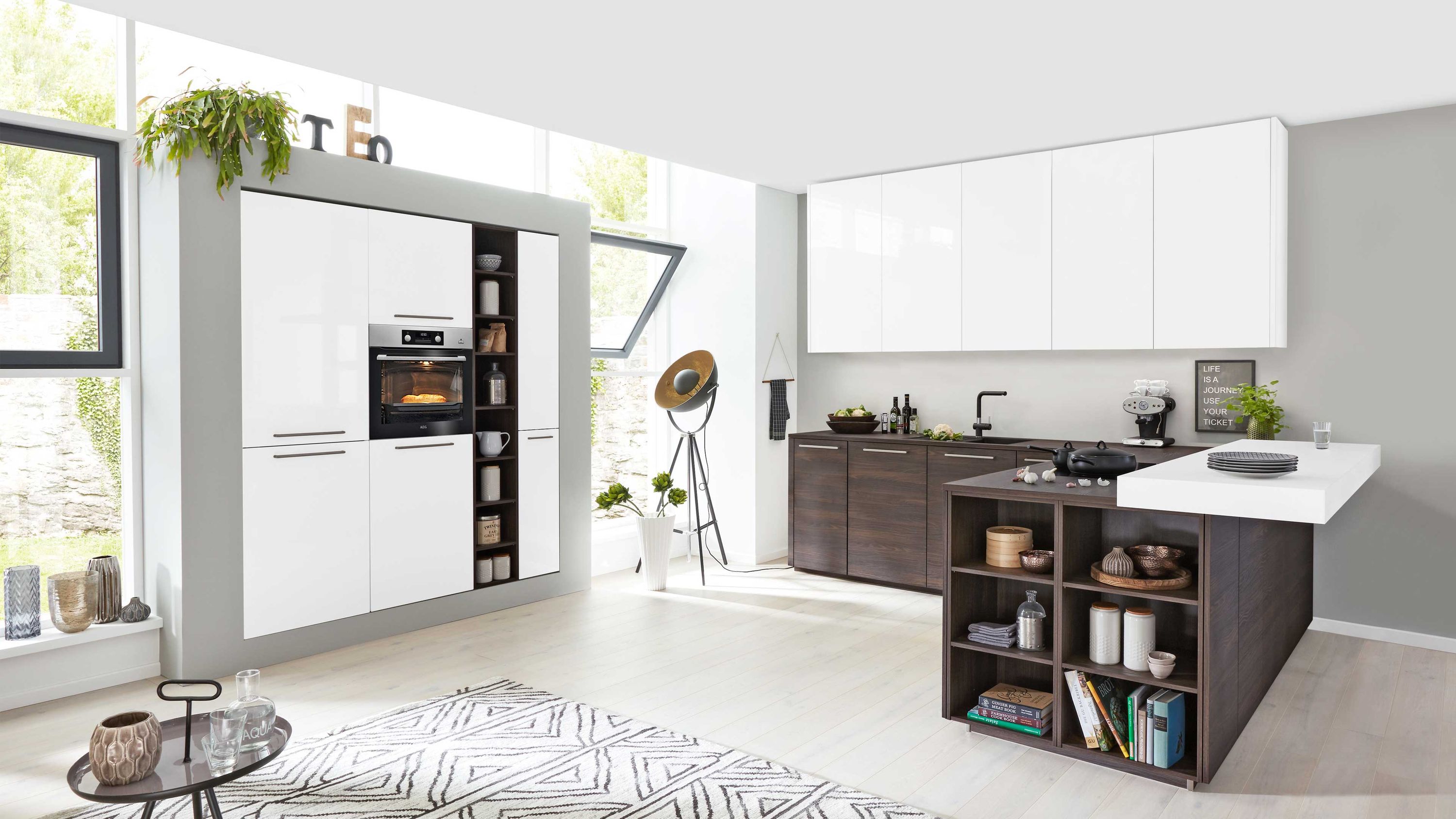 Küche mit Essbereich und kontrastreicher Gestaltung Weiße und braune Schränke Insel mit Essplatte offene Regale Fensterlicht Pflanzen und Küchenaccessoires